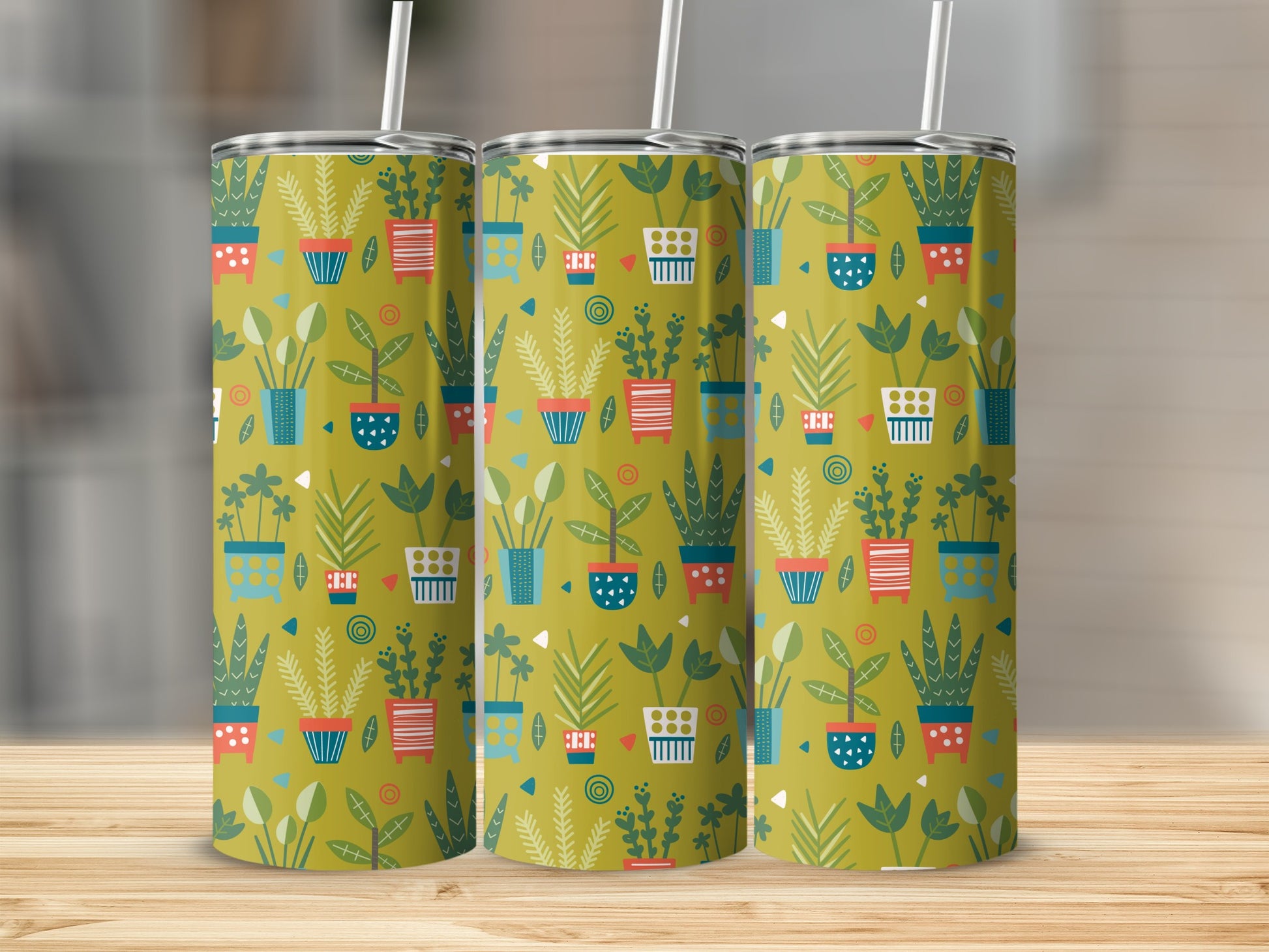 Three tumblers on a wooden surface with a patterned design of potted plants.