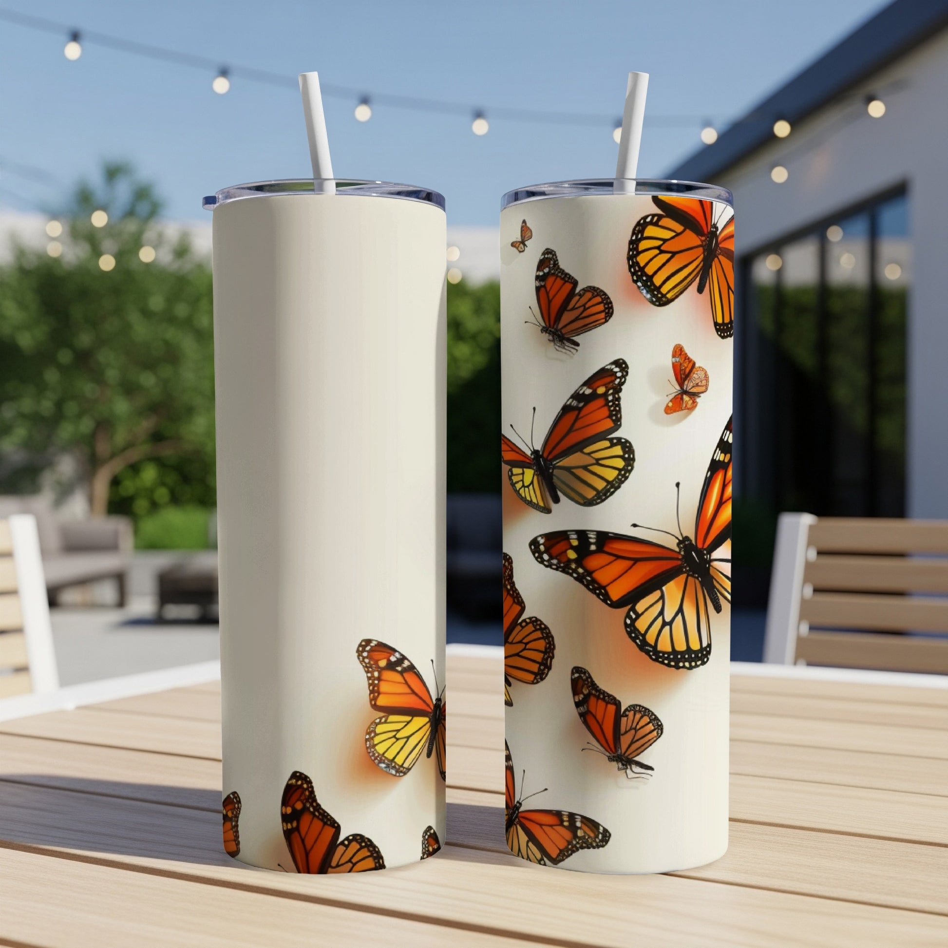 Two cream tumblers with orange monarch butterflies scattered across them.