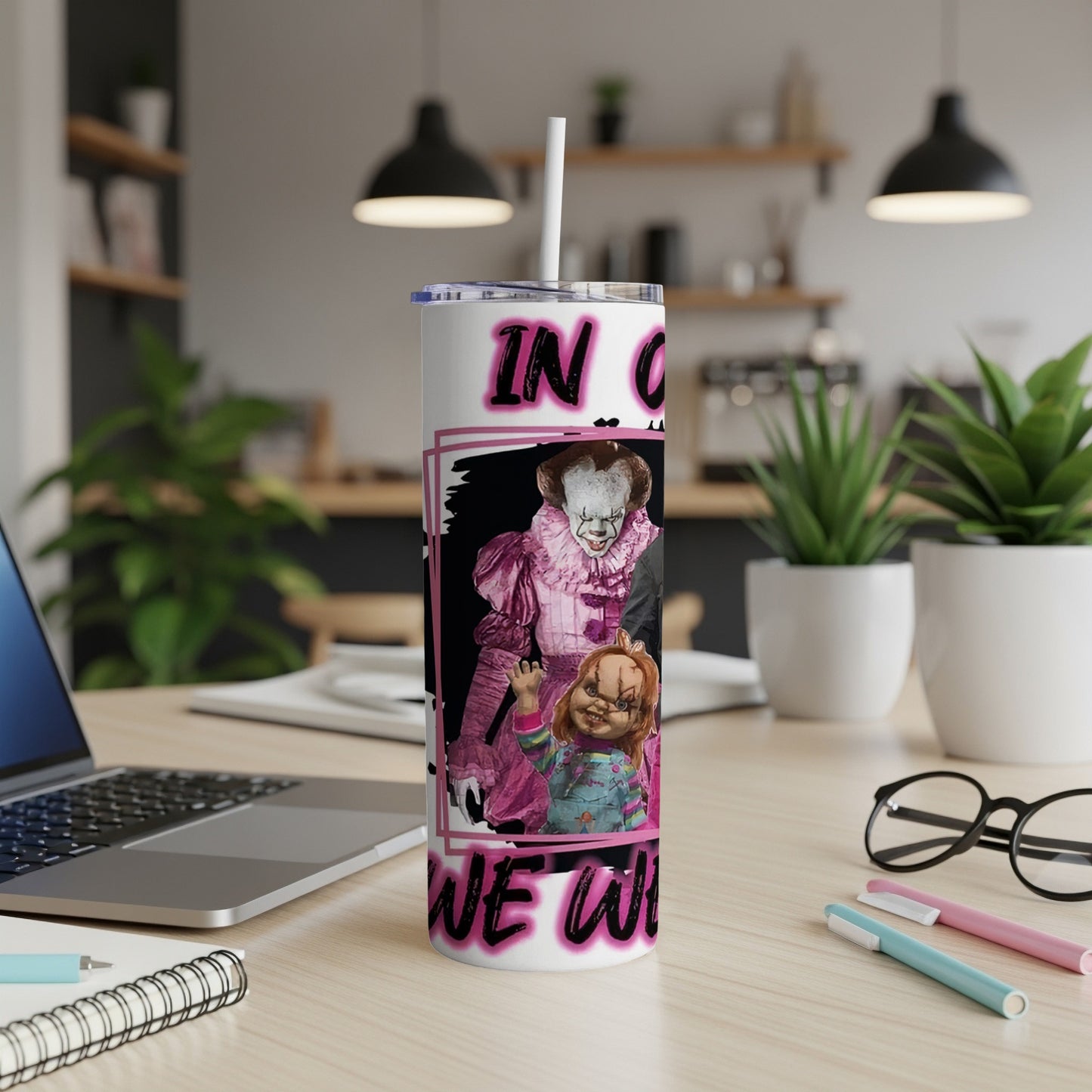 Creepy characters including Pennywise and Chucky on a pink and black tumbler.