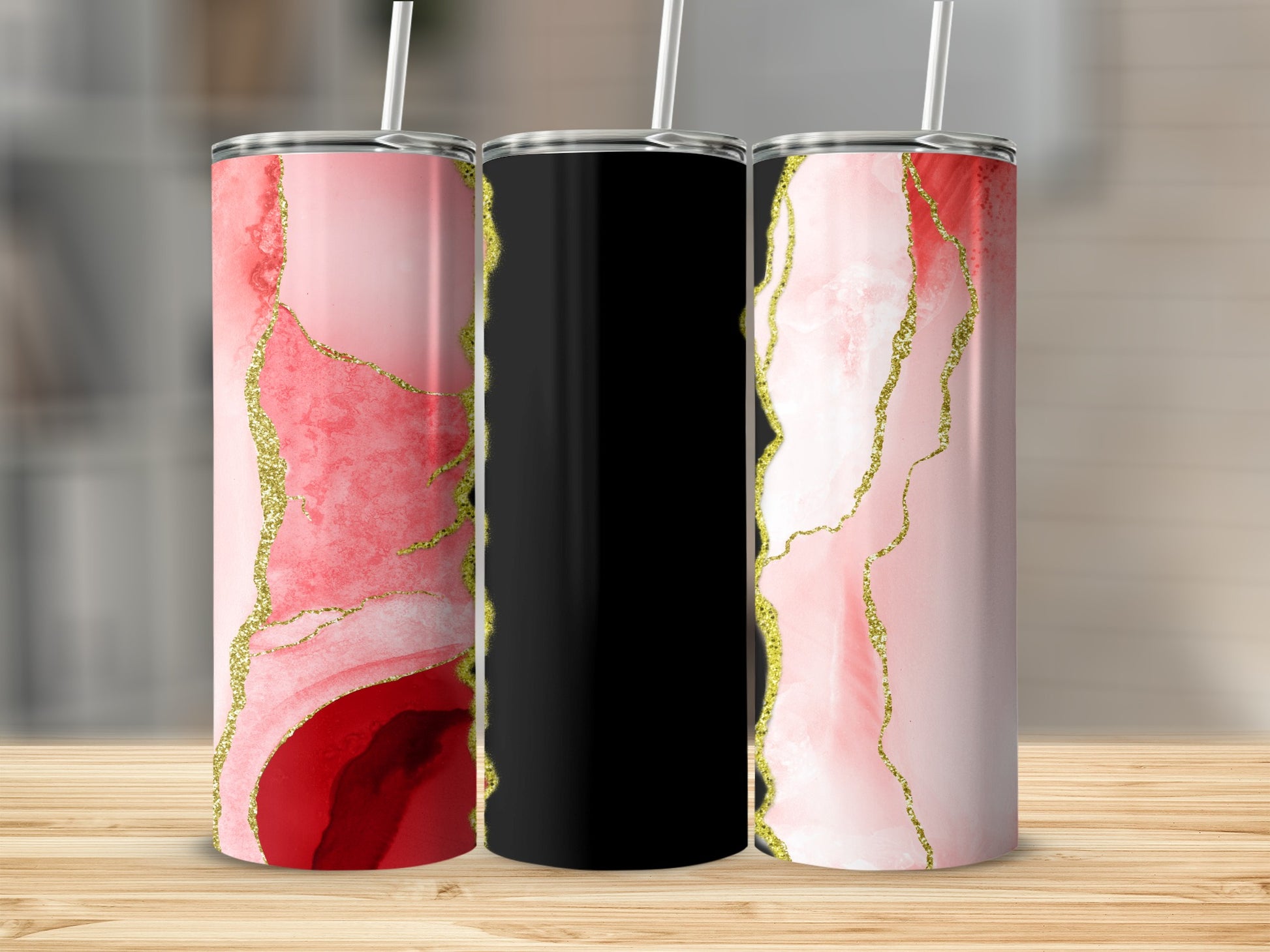 Three tumblers with pink marble and gold abstract designs, one black.