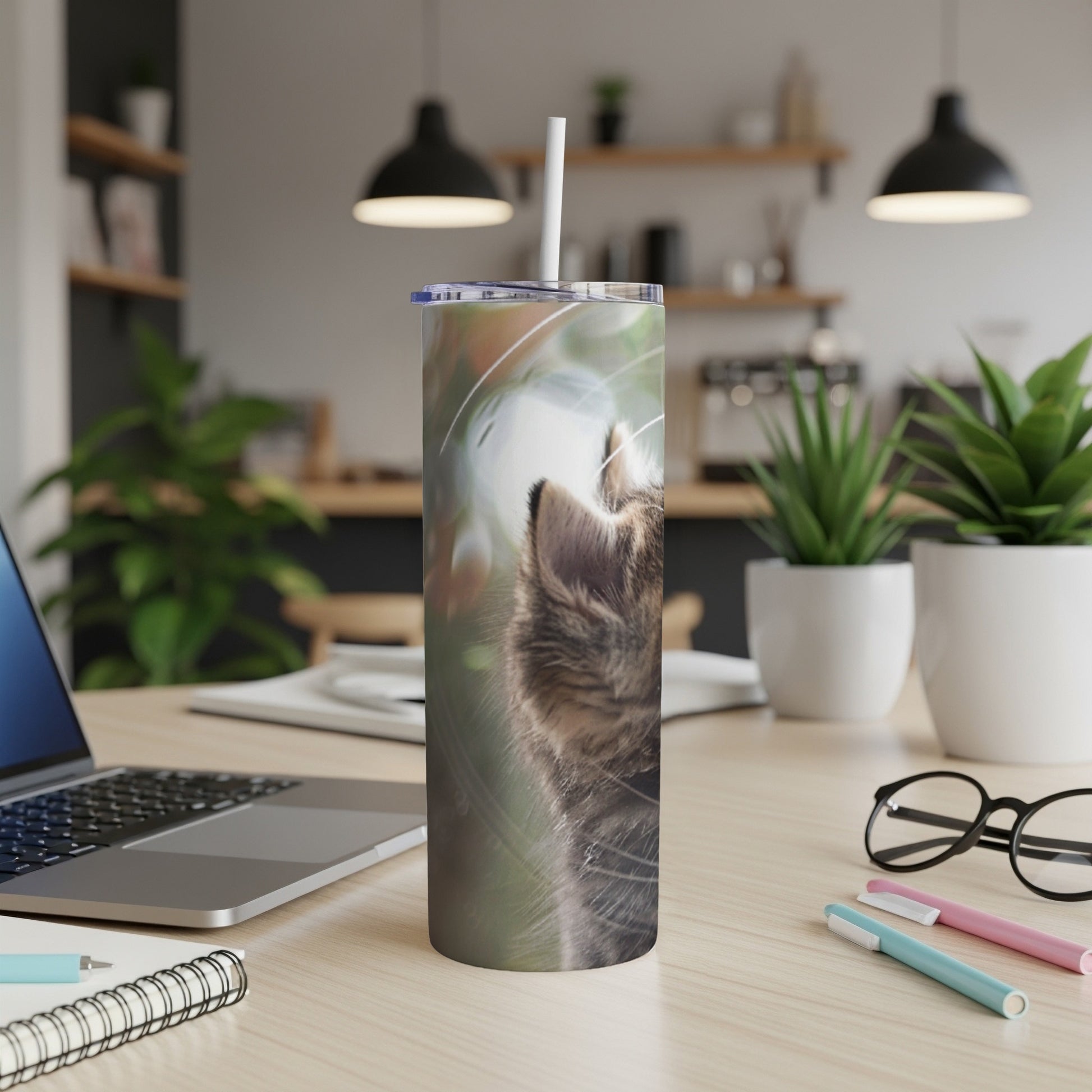 Tabby cat face close-up on a white tumbler with a straw.