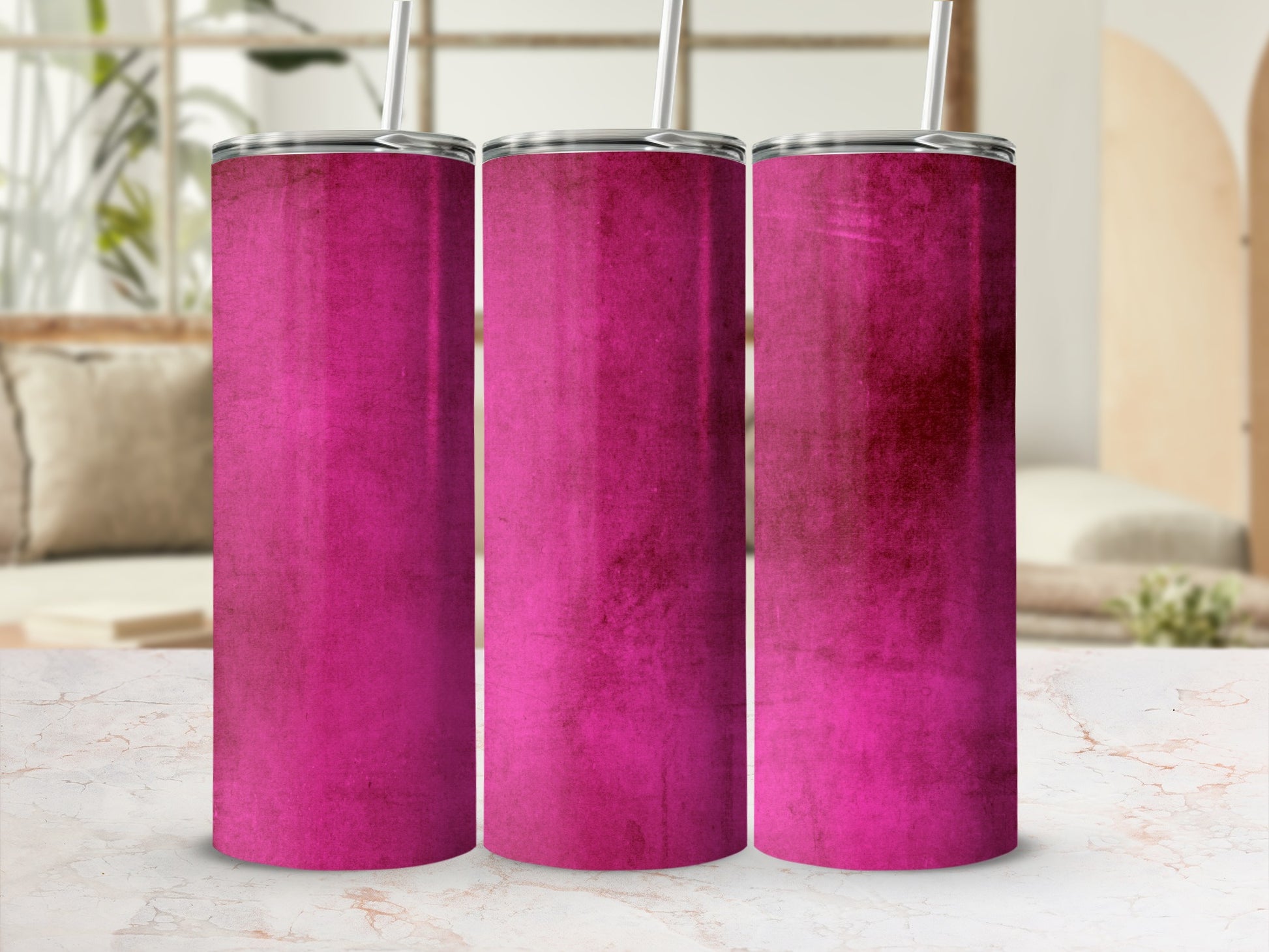Three magenta tumblers with straws on a marble surface.