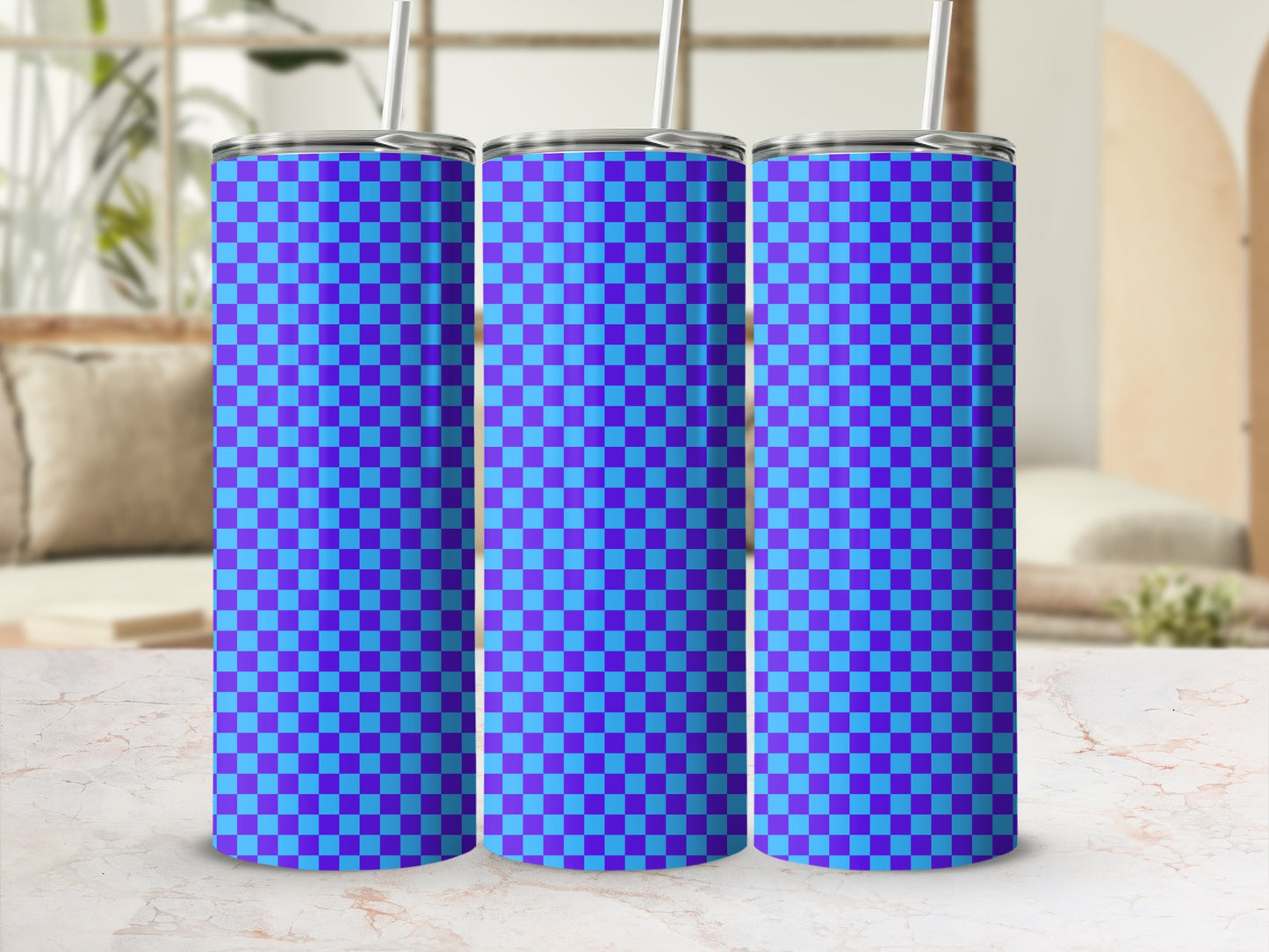 Three blue and purple checkered tumblers with straws on a marble surface.