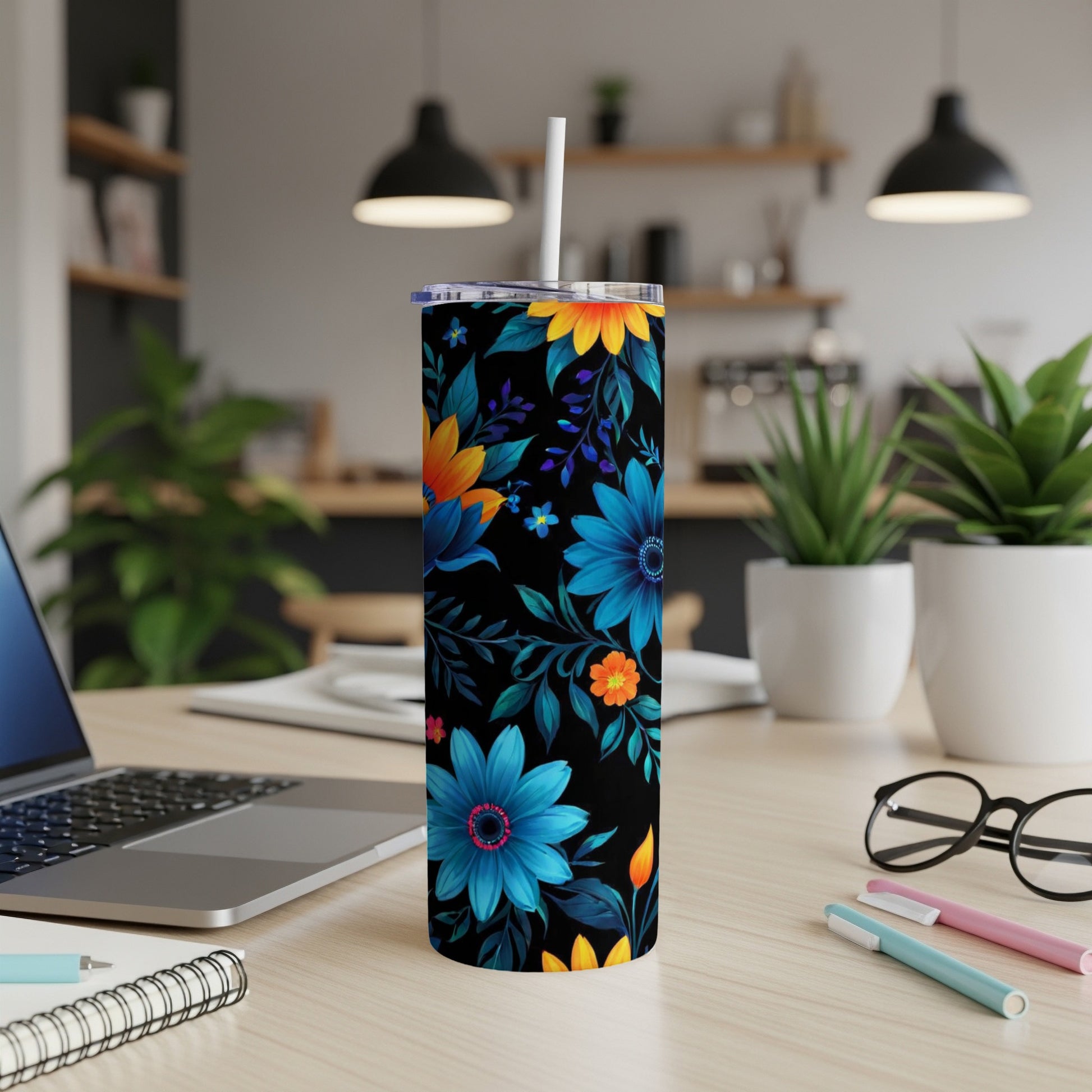 Black tumbler with vibrant blue and orange floral pattern and white straw.