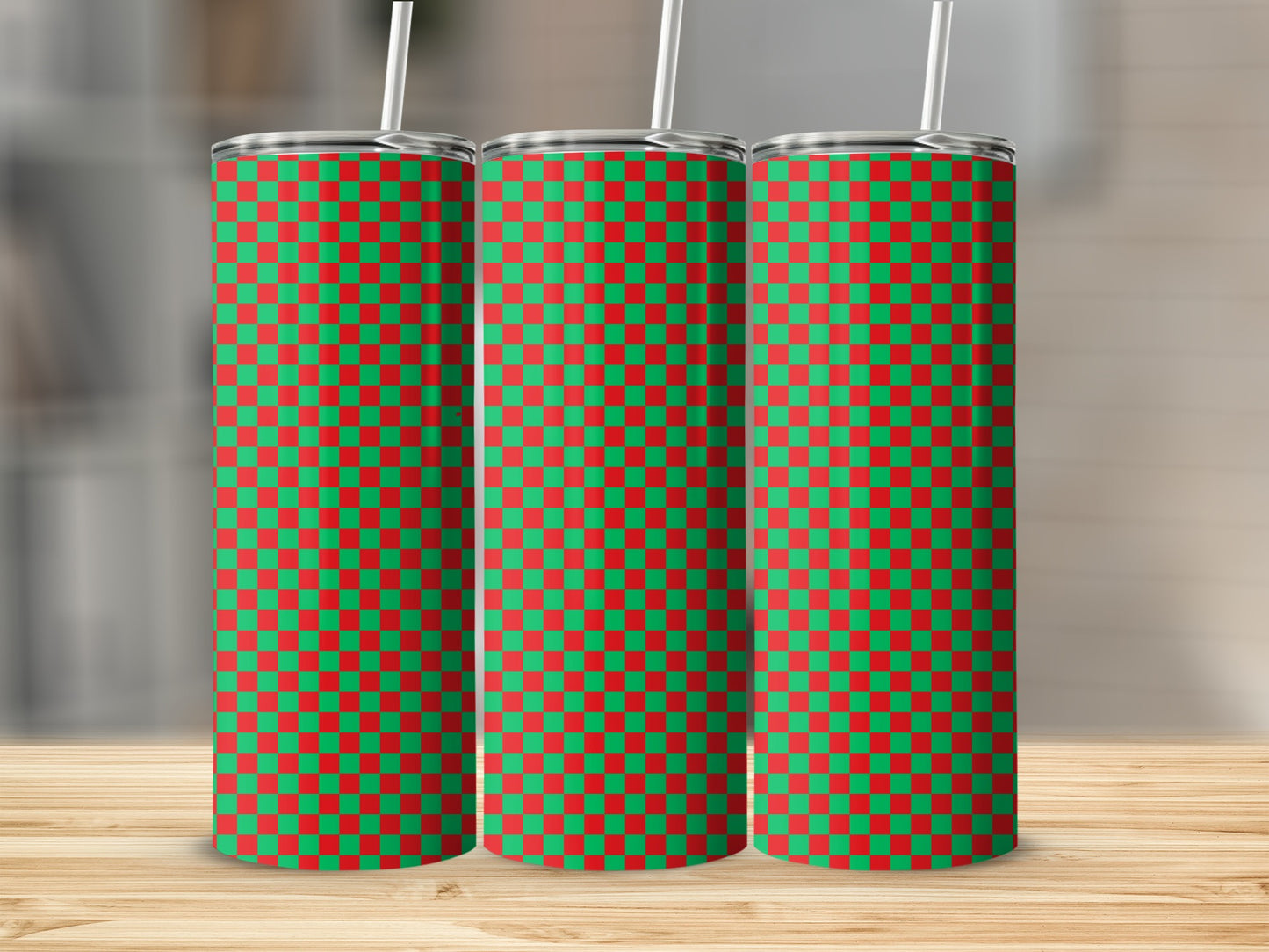 Three tumblers with a red and green checkered pattern and white straws.