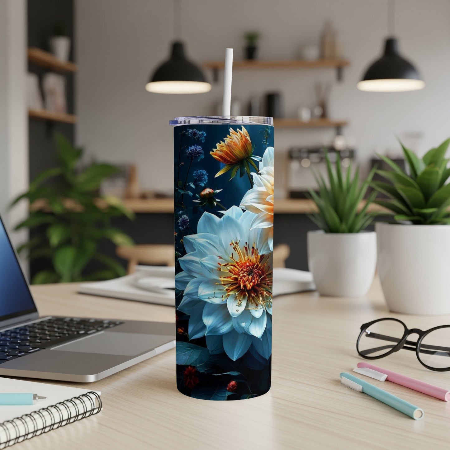 Floral patterned tumbler with a white straw on a desk.