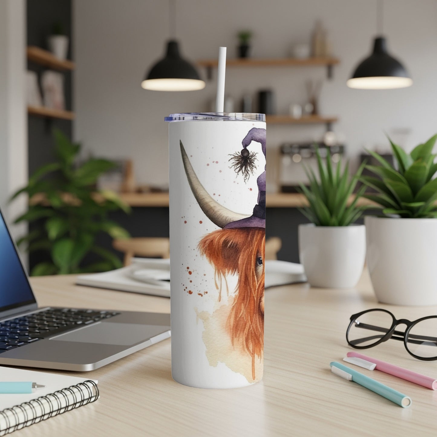 Highland cow wearing a witch hat with a spider on a white tumbler.