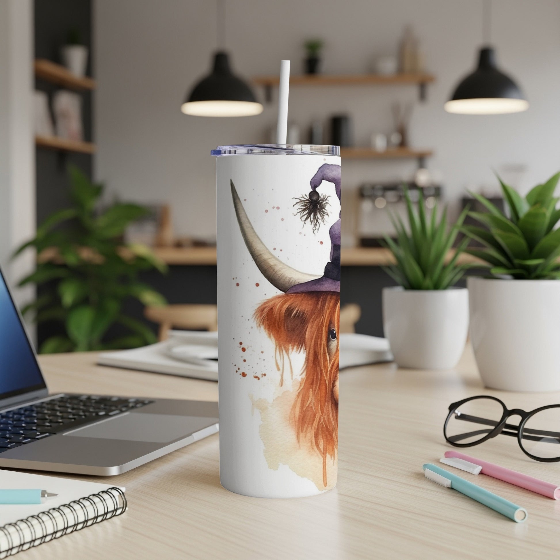 Highland cow wearing a witch hat with a spider on a white tumbler.
