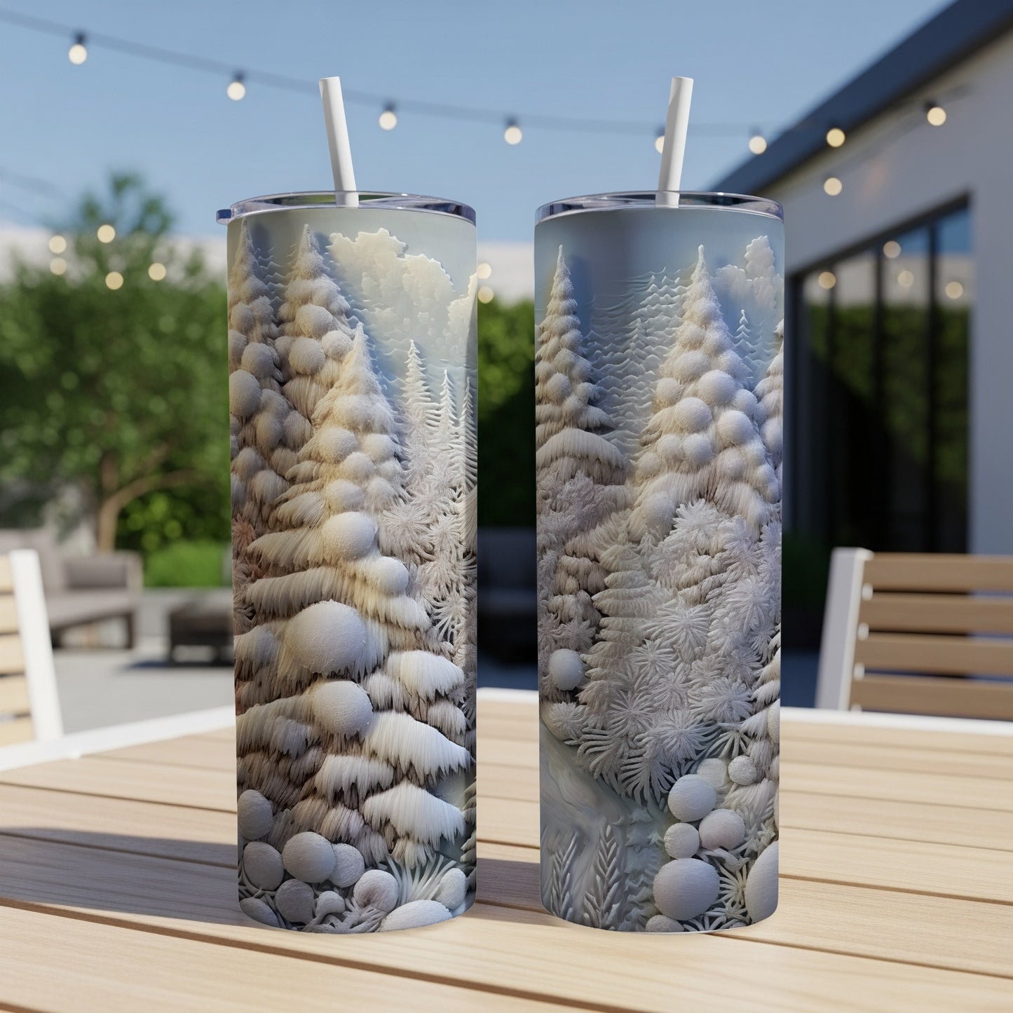 Two snow-covered pine trees on a white tumbler, resting on a wooden table outdoors.