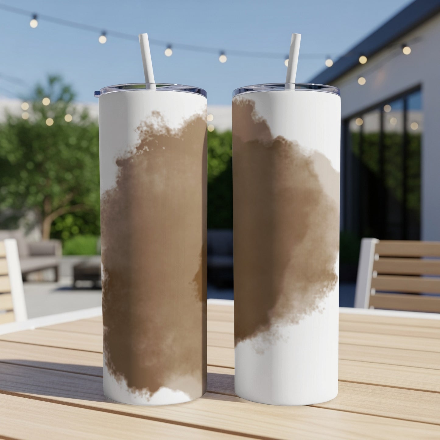 Two white tumblers with brown watercolor stains, on a wooden table.