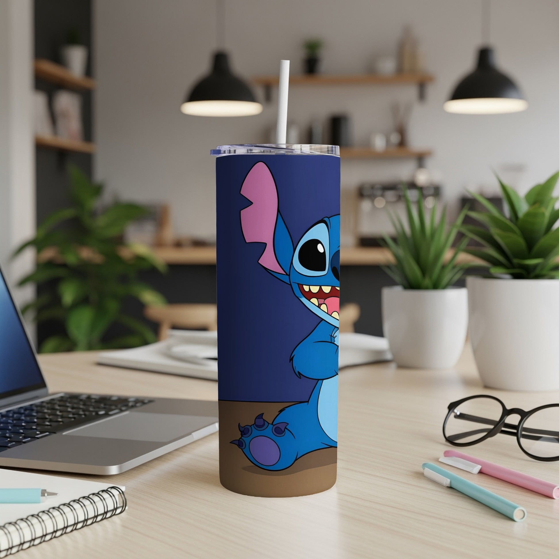 Blue Stitch tumbler with straw on desk, laptop and pens visible.