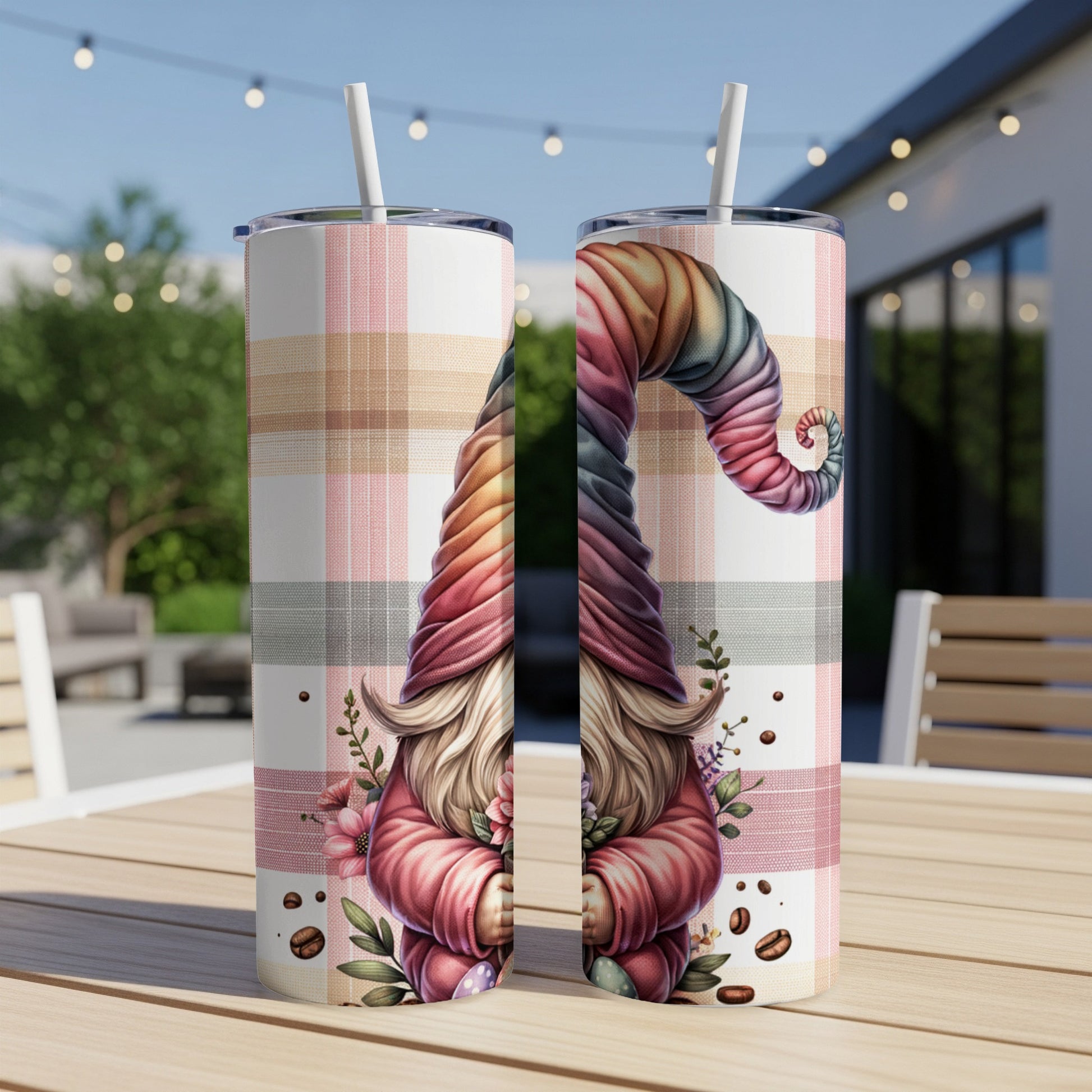 Two tumblers with a colorful gnome and plaid pattern on an outdoor table.