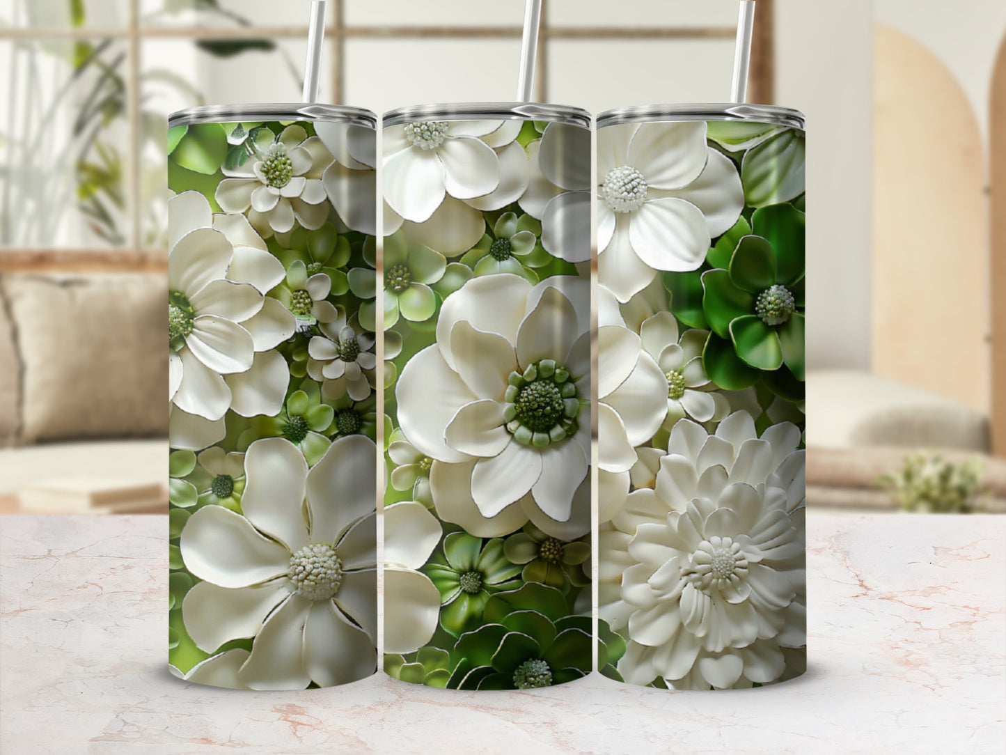 Three tumblers with a white and green floral pattern and straws.