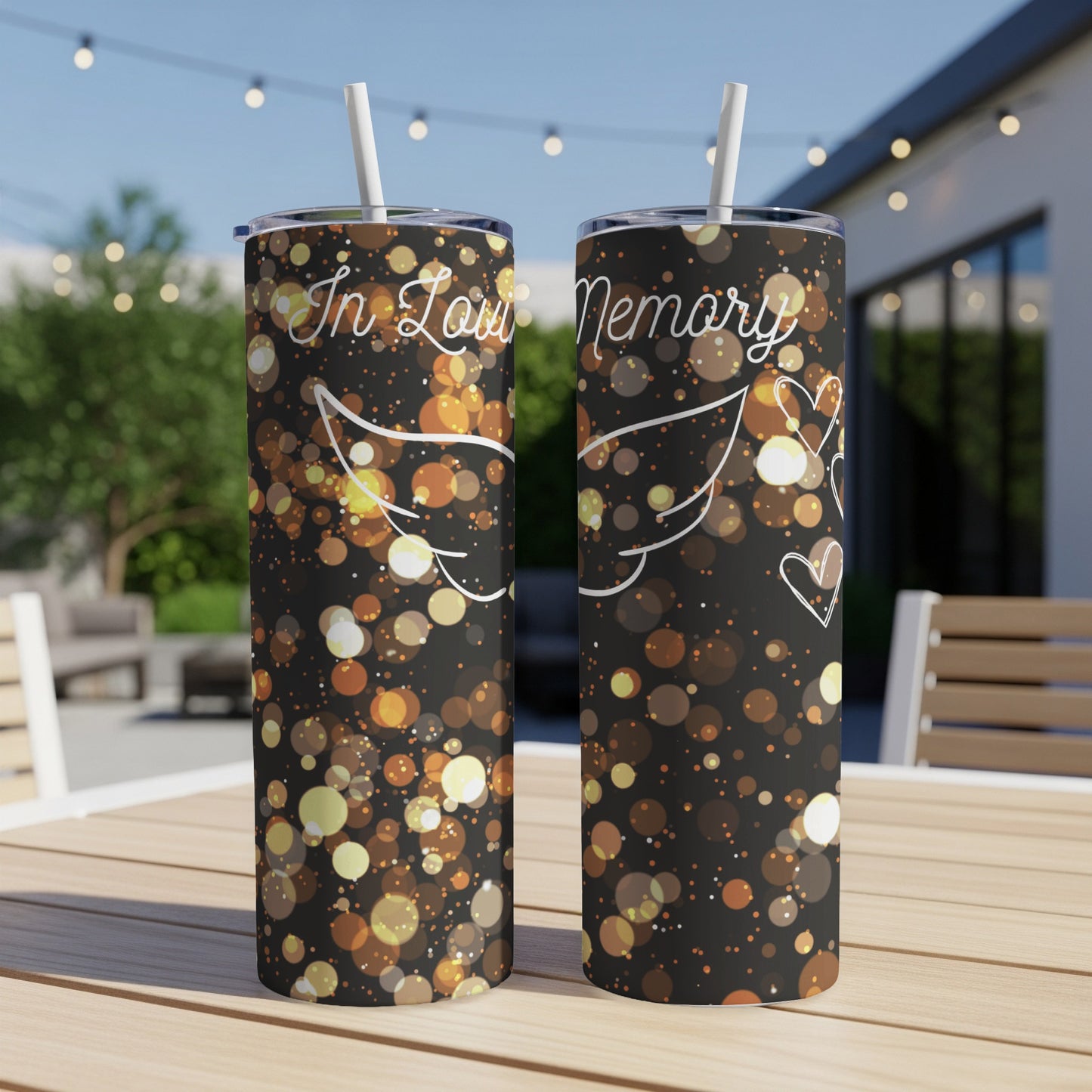 Two tumblers with "In Loving Memory" text and angel wings on a dark, bokeh background.