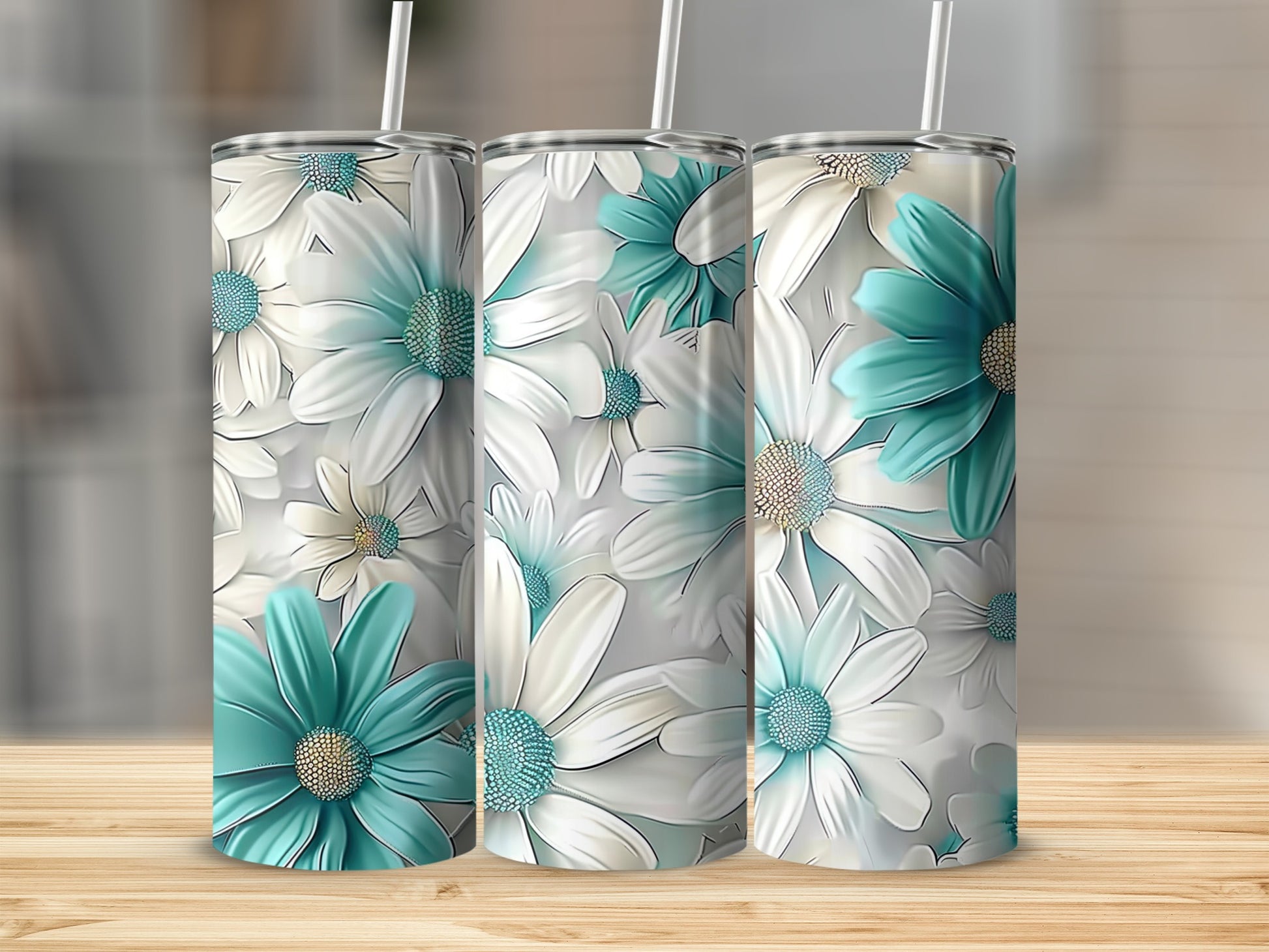 Three tumblers with teal and white floral pattern on wooden surface.
