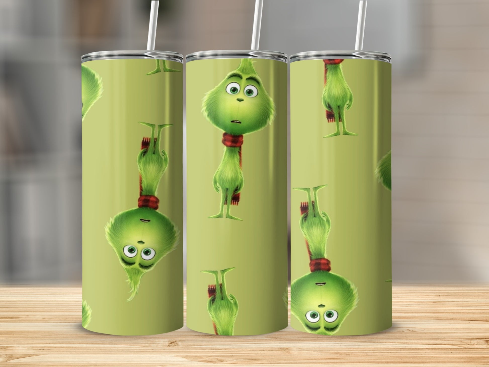 Green tumbler with repeating pattern of the Grinch wearing a red scarf.