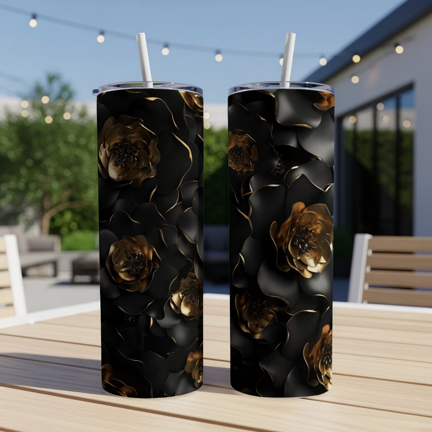 Two black tumblers with gold floral pattern, set on a table.