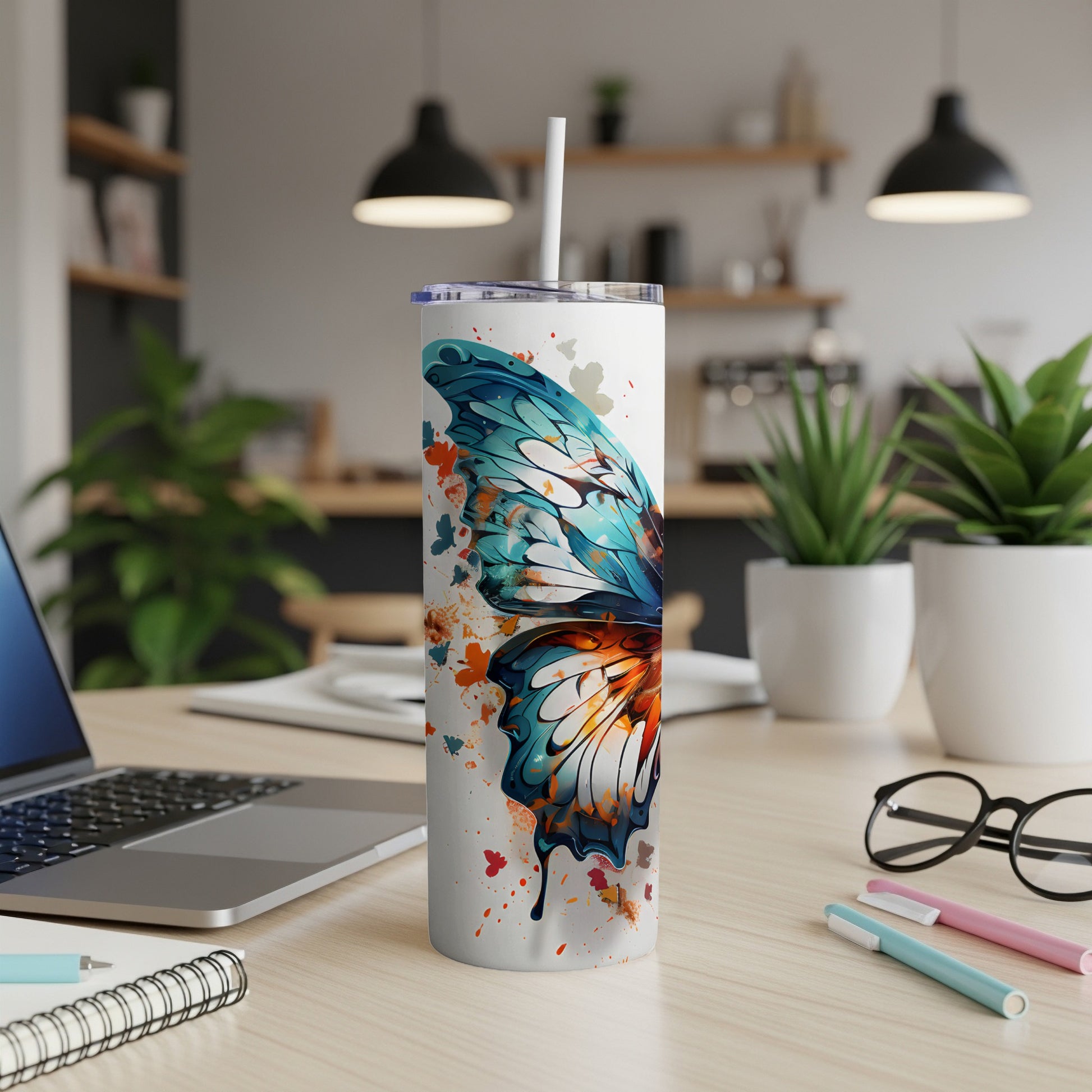 White tumbler with colorful butterfly wing design and straw.
