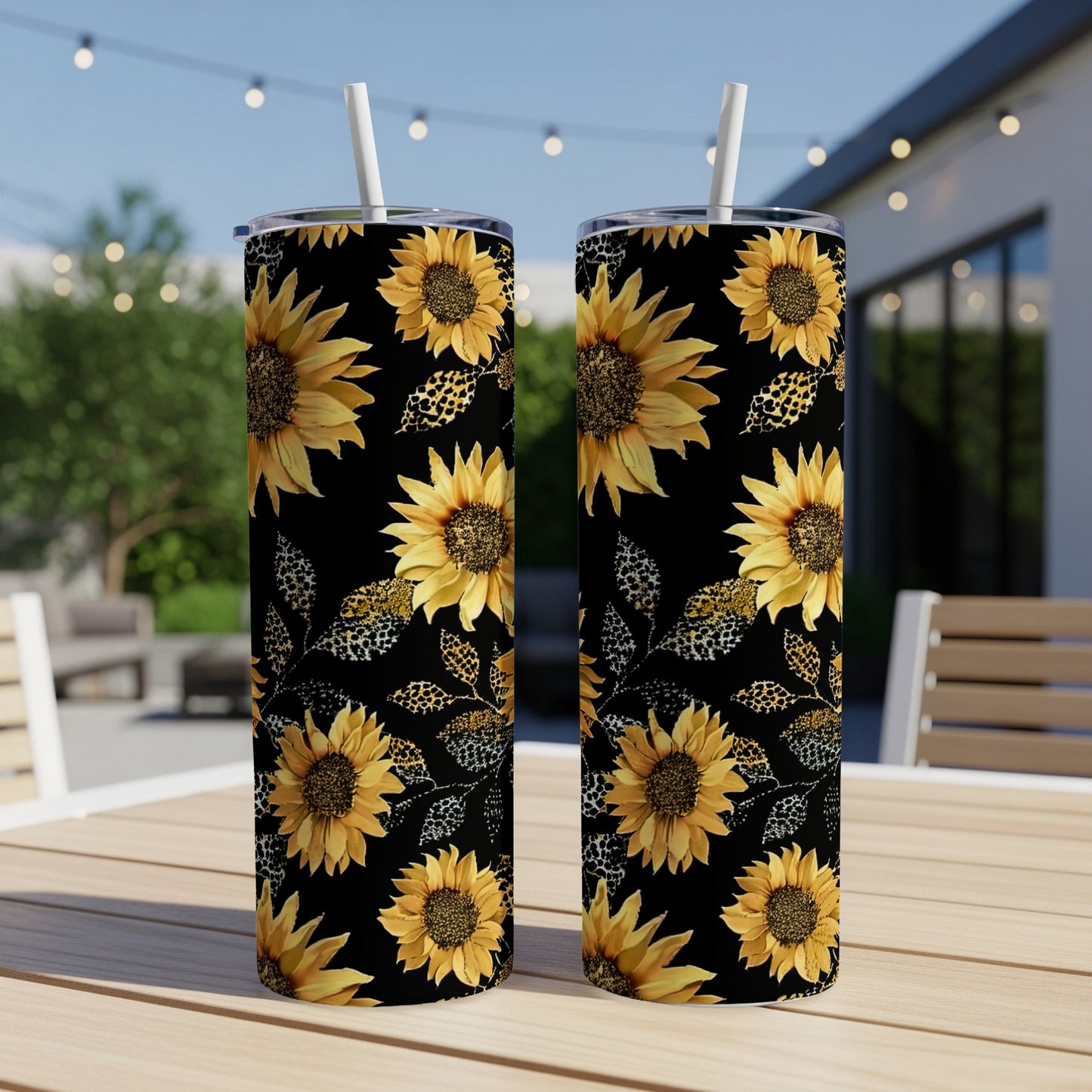 Two black tumblers with sunflower and leopard print pattern, with straws.