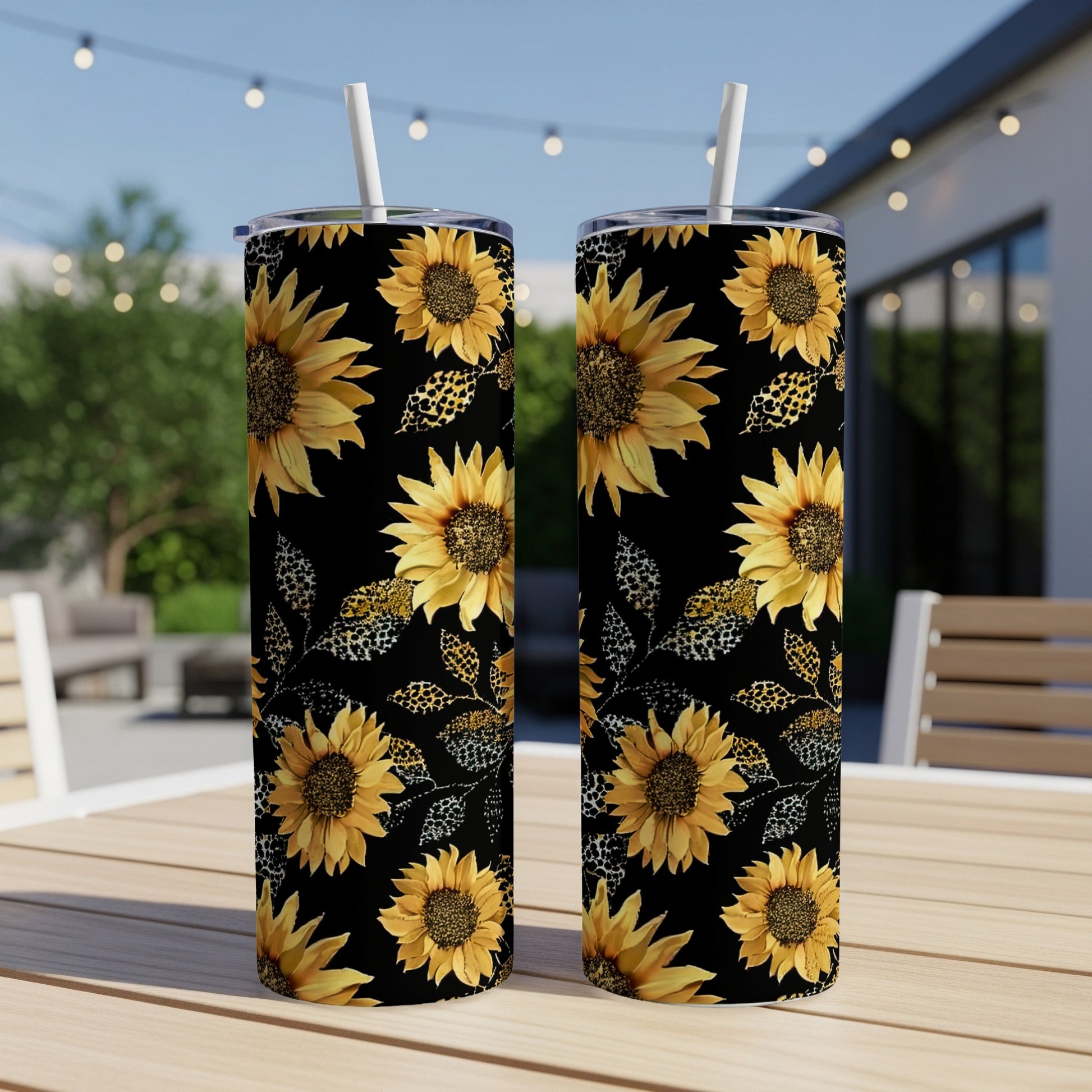 Two black tumblers with sunflower and leopard print pattern, with straws.