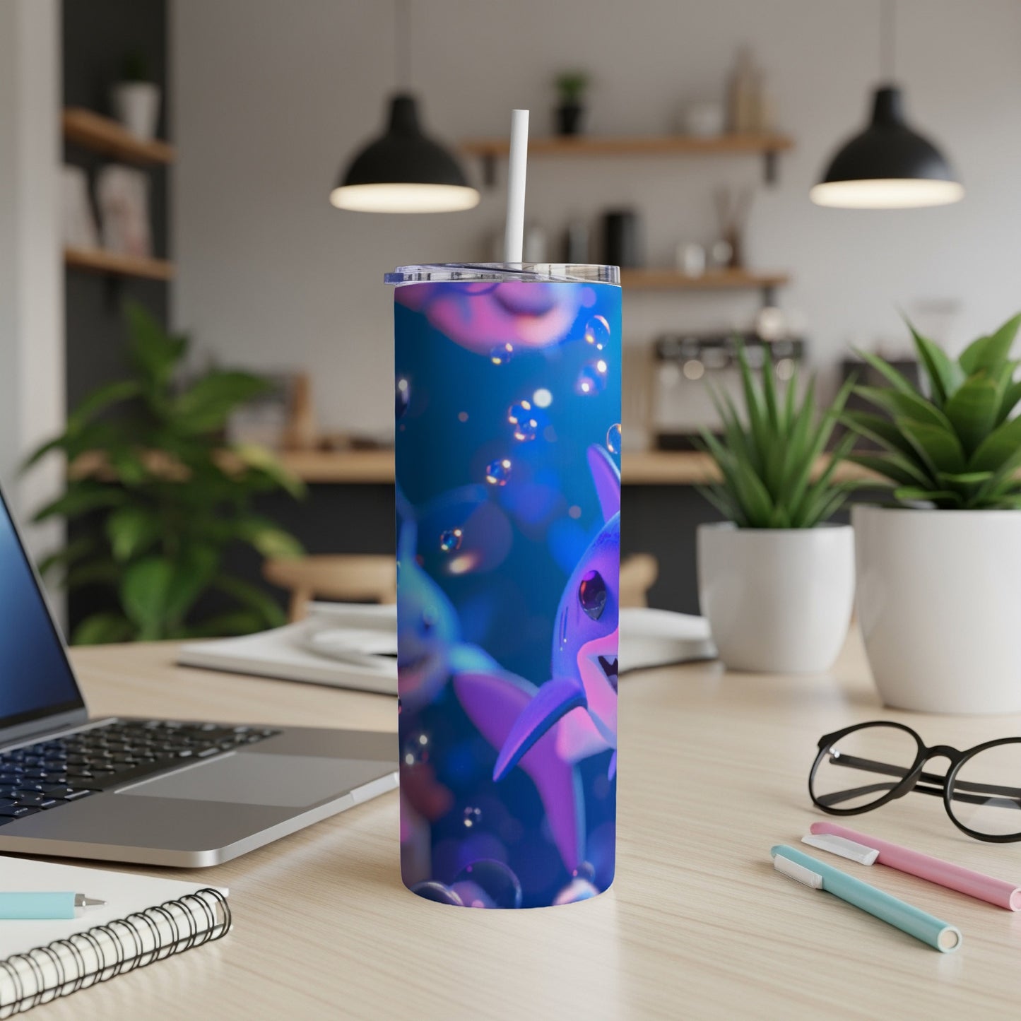 Blue tumbler with cartoon sharks and bubbles, straw inserted.