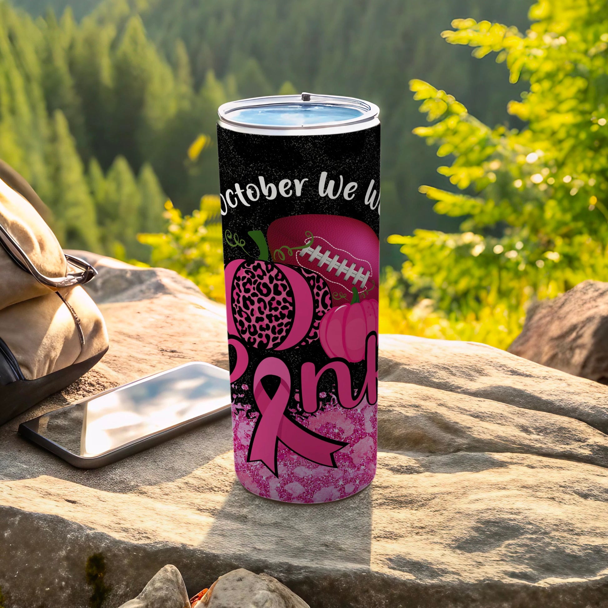Tumbler with pink ribbon and pumpkins, celebrating breast cancer awareness month.