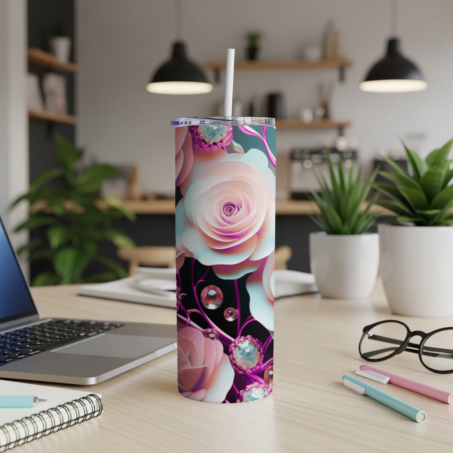Pink and white floral patterned tumbler with straw on a desk.