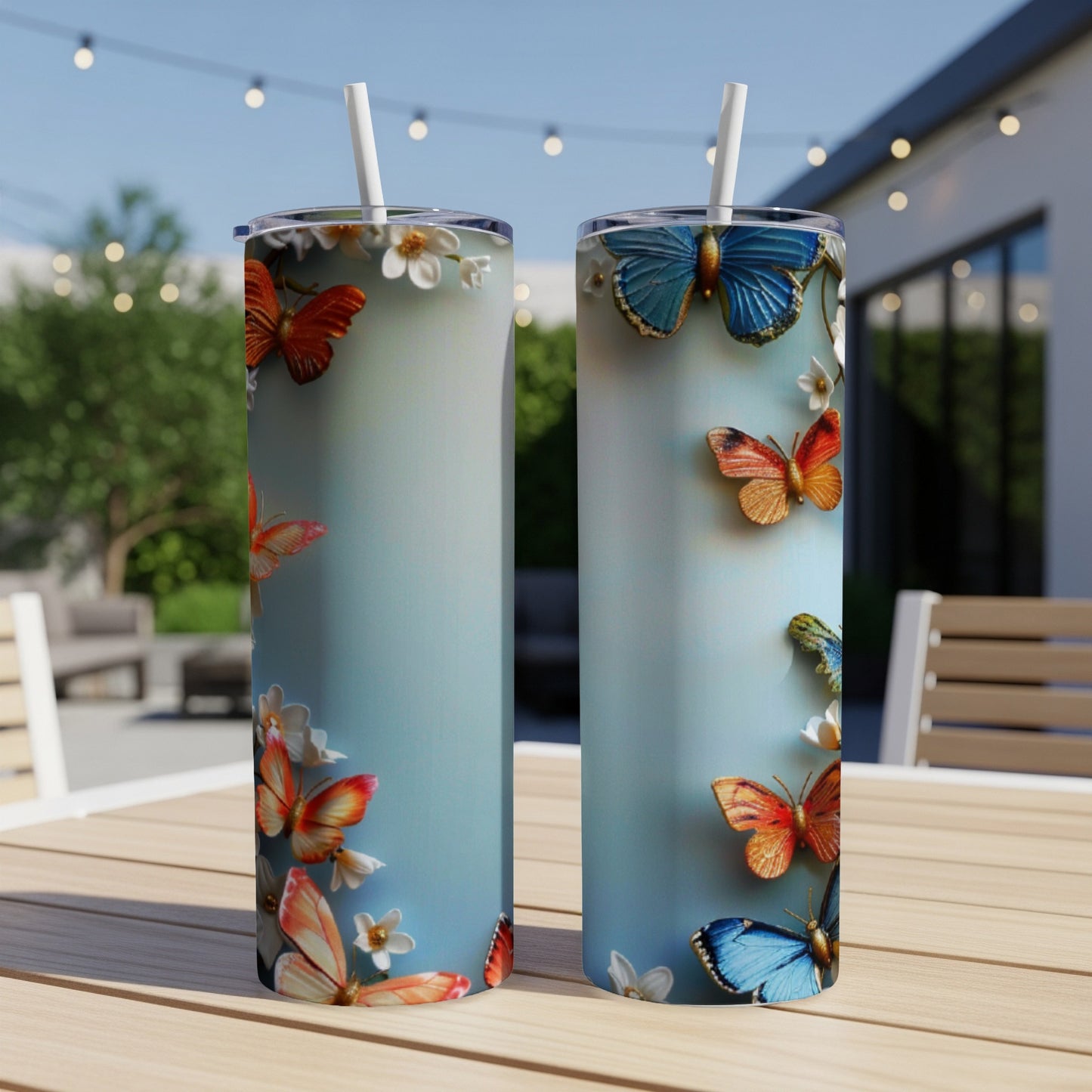 Two tall, blue tumblers with colorful butterflies, resting on a table.
