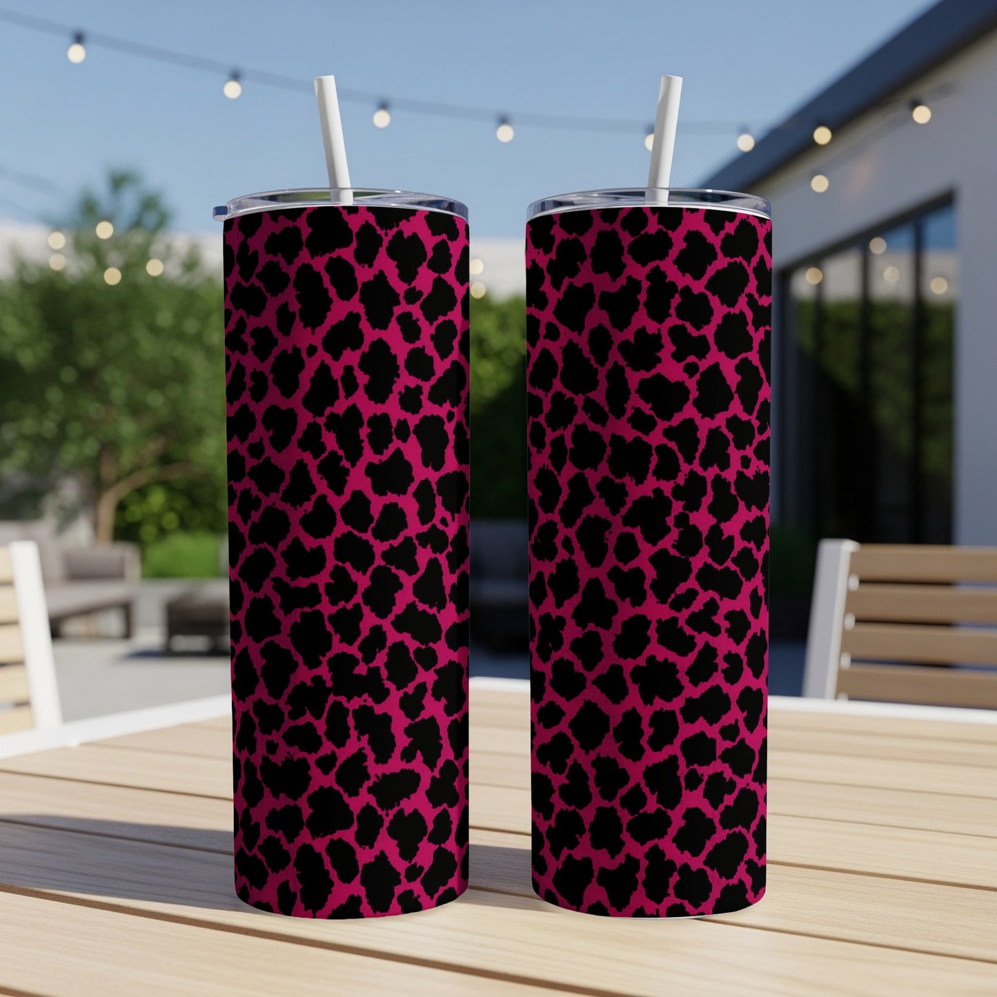 Two tall tumblers with a pink and black leopard print pattern and white straws.