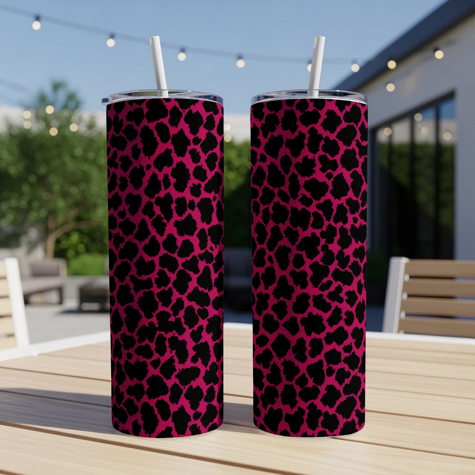 Two tall tumblers with a pink and black leopard print pattern and white straws.