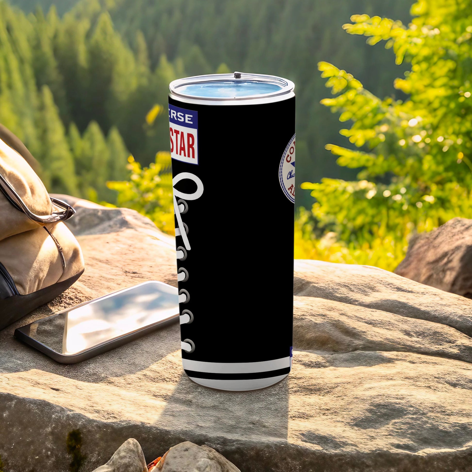 Black Converse sneaker-themed tumbler with white laces on a rock.
