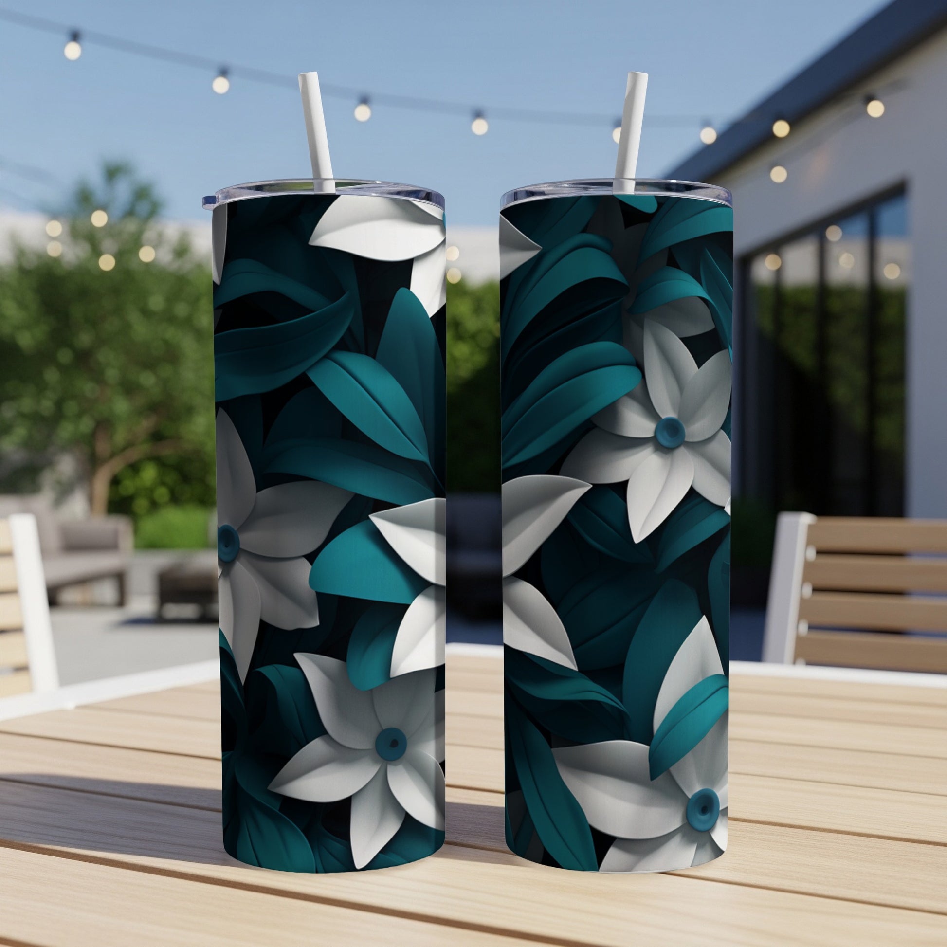 Two tumblers with teal and white floral pattern on a wooden table.