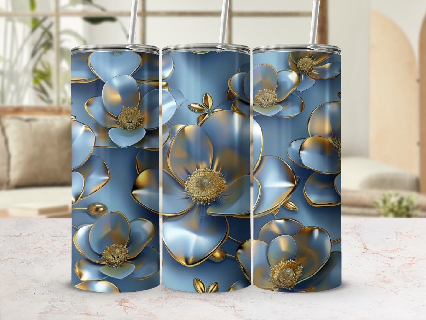 Three blue floral tumblers with gold accents, displayed on a marbled surface.