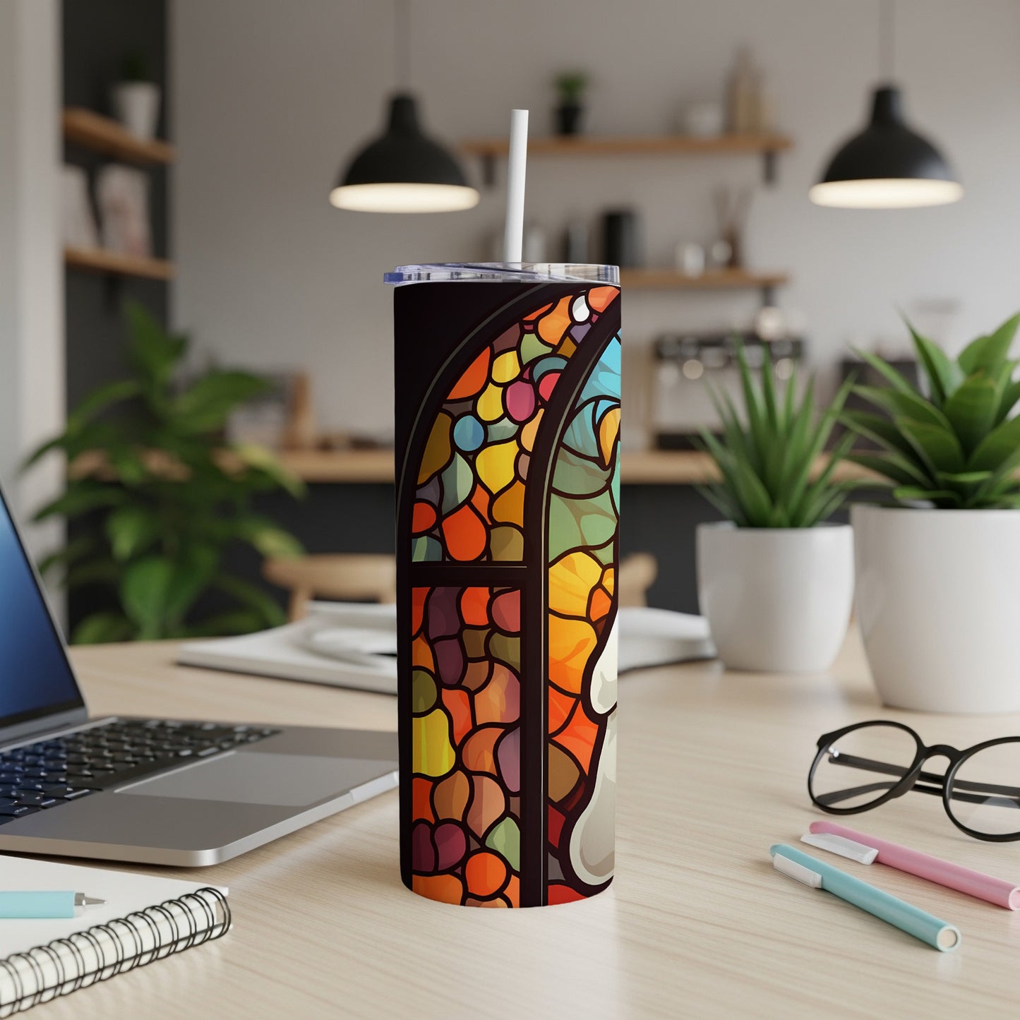 Stained glass pattern tumbler with straw on a desk.