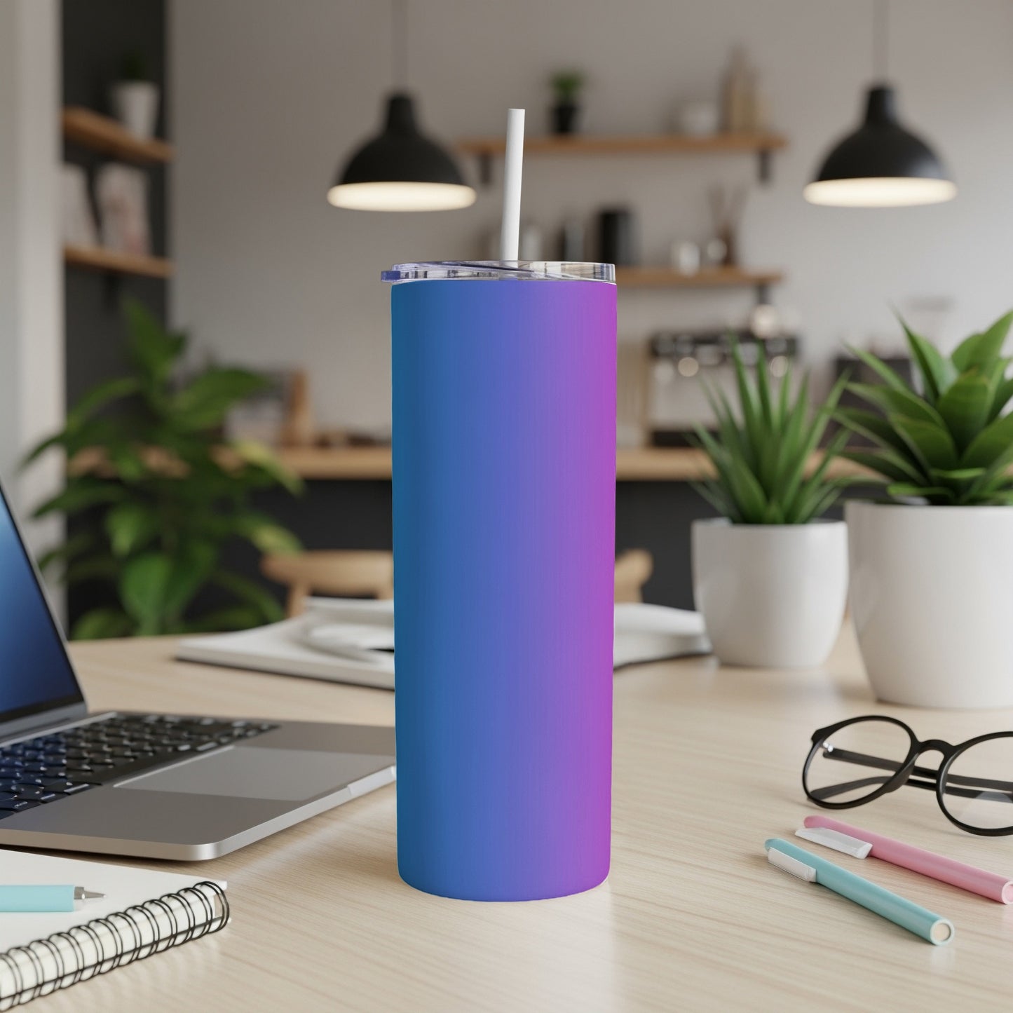 Gradient blue and purple tumbler with straw on a desk.