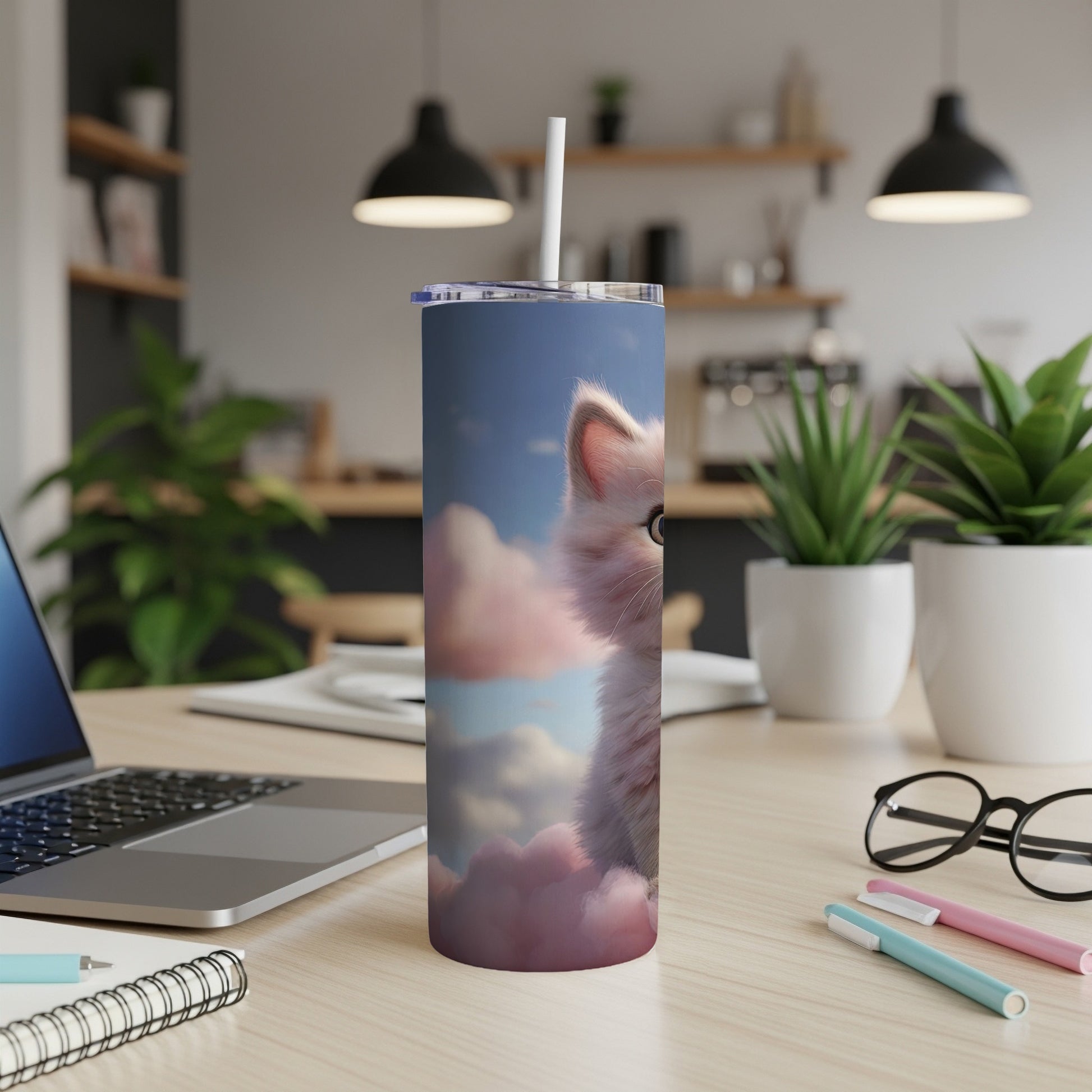 Fluffy white kitten sits on pink clouds with straw in a tall tumbler.