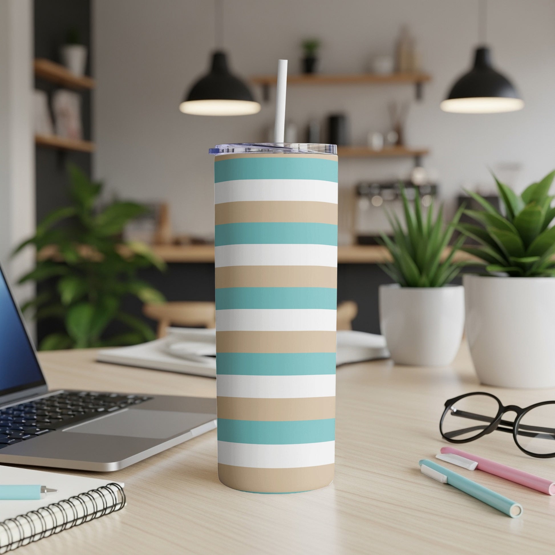 Striped tumbler with blue, beige, and white bands on a desk.
