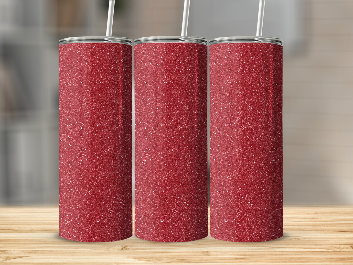 Three red glitter tumblers with white straws on a wooden surface.
