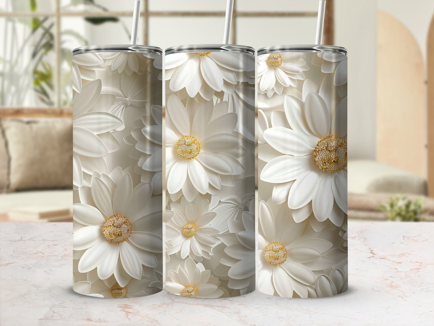 Three white floral tumblers with straws on a marble surface.