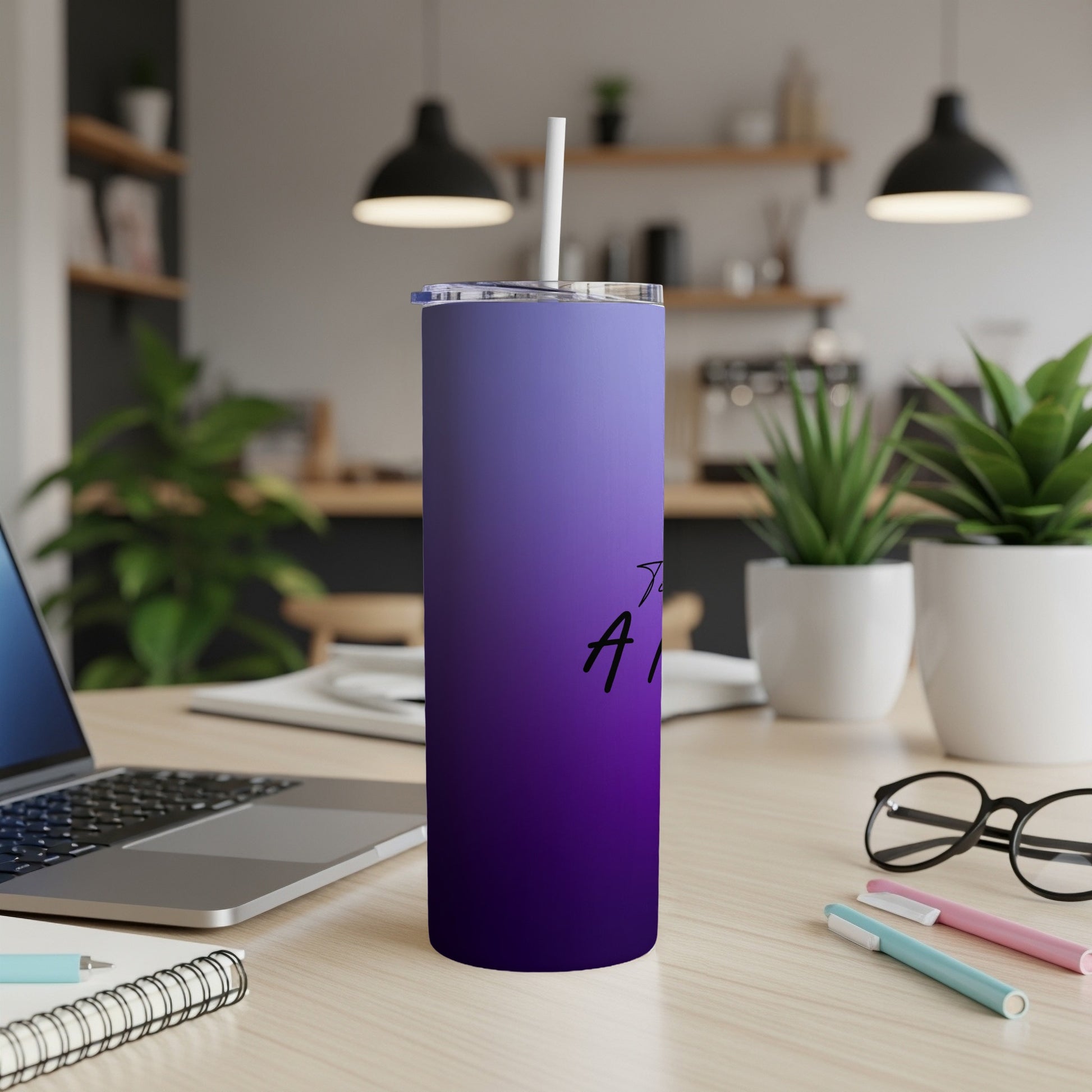 Purple gradient tumbler with "And..." text on a wooden desk.