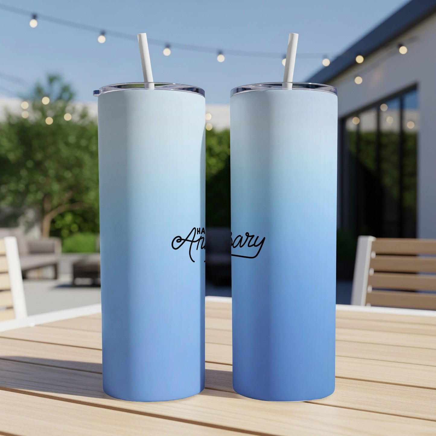 Two blue gradient tumblers with "Anniversary" text sit on a wooden table.