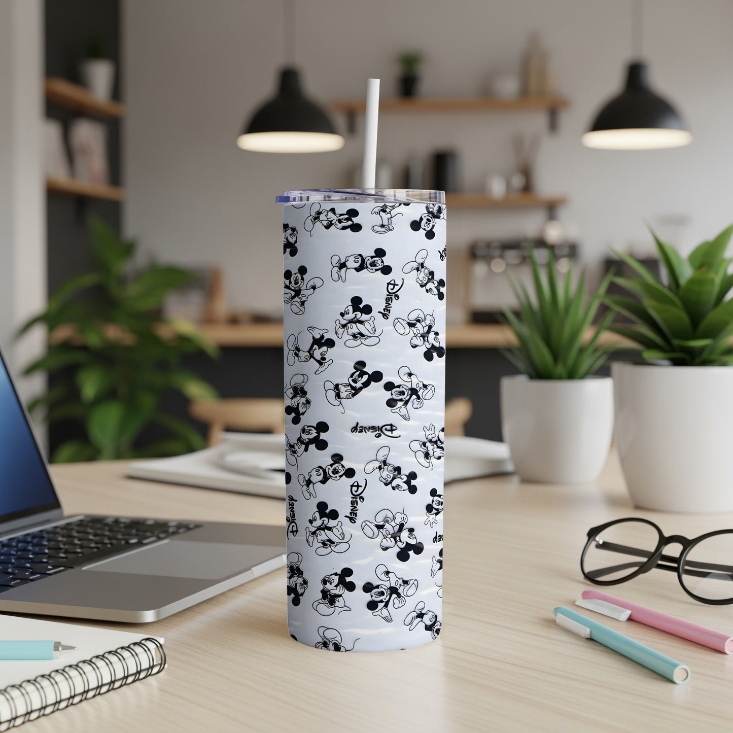 White tumbler with a repeating Mickey Mouse pattern and a straw.