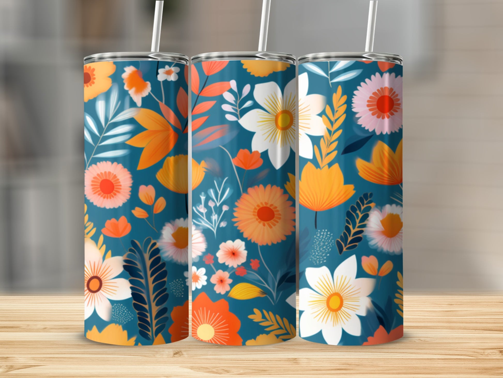 Three tumblers with a vibrant floral pattern on a wooden surface.