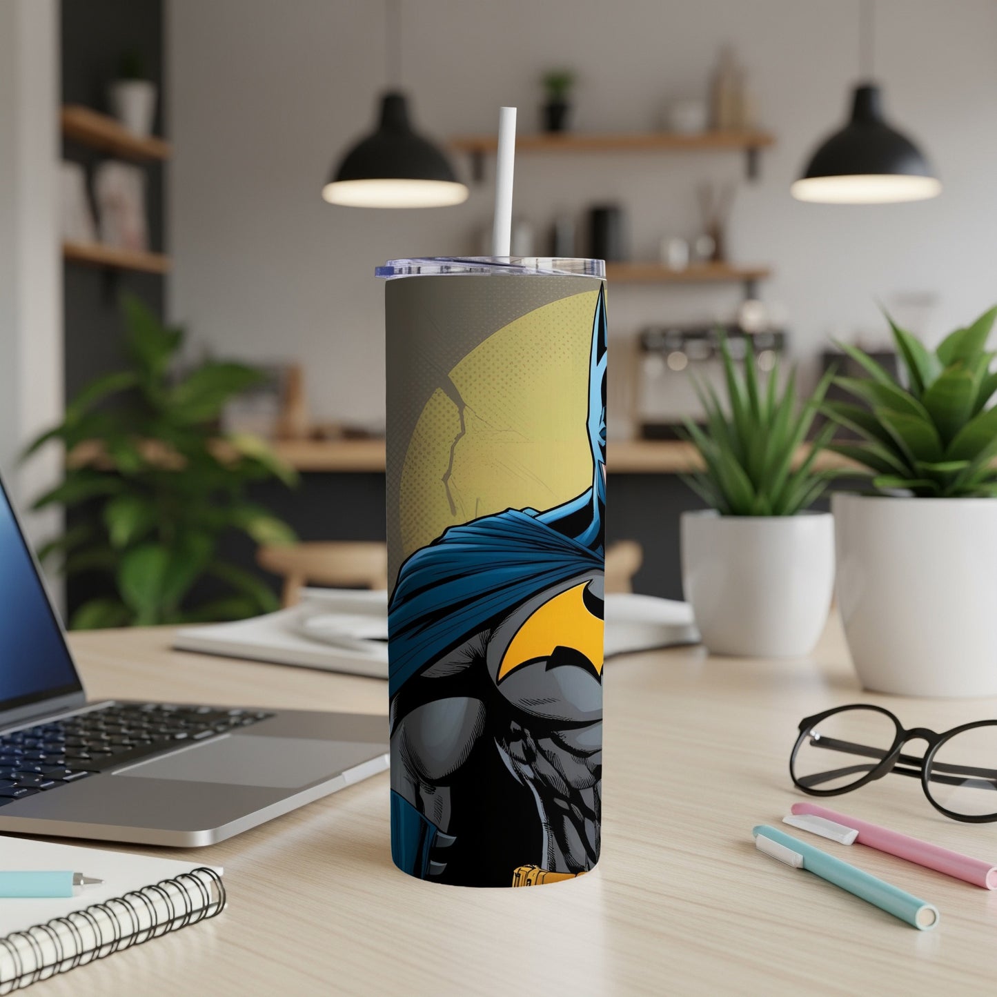 Batman tumbler with black and yellow logo on desk.