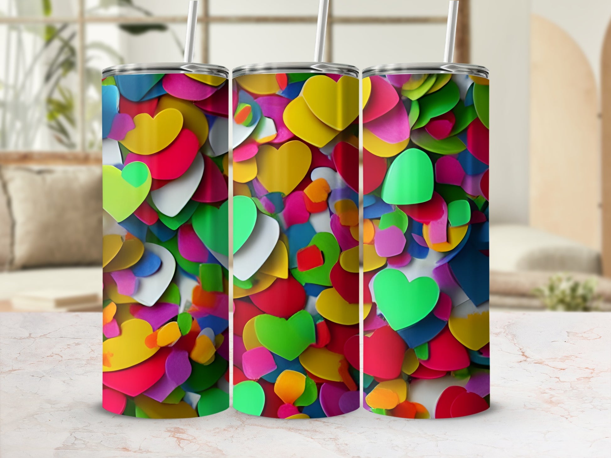 Three colorful, patterned tumblers with heart designs displayed on a counter.