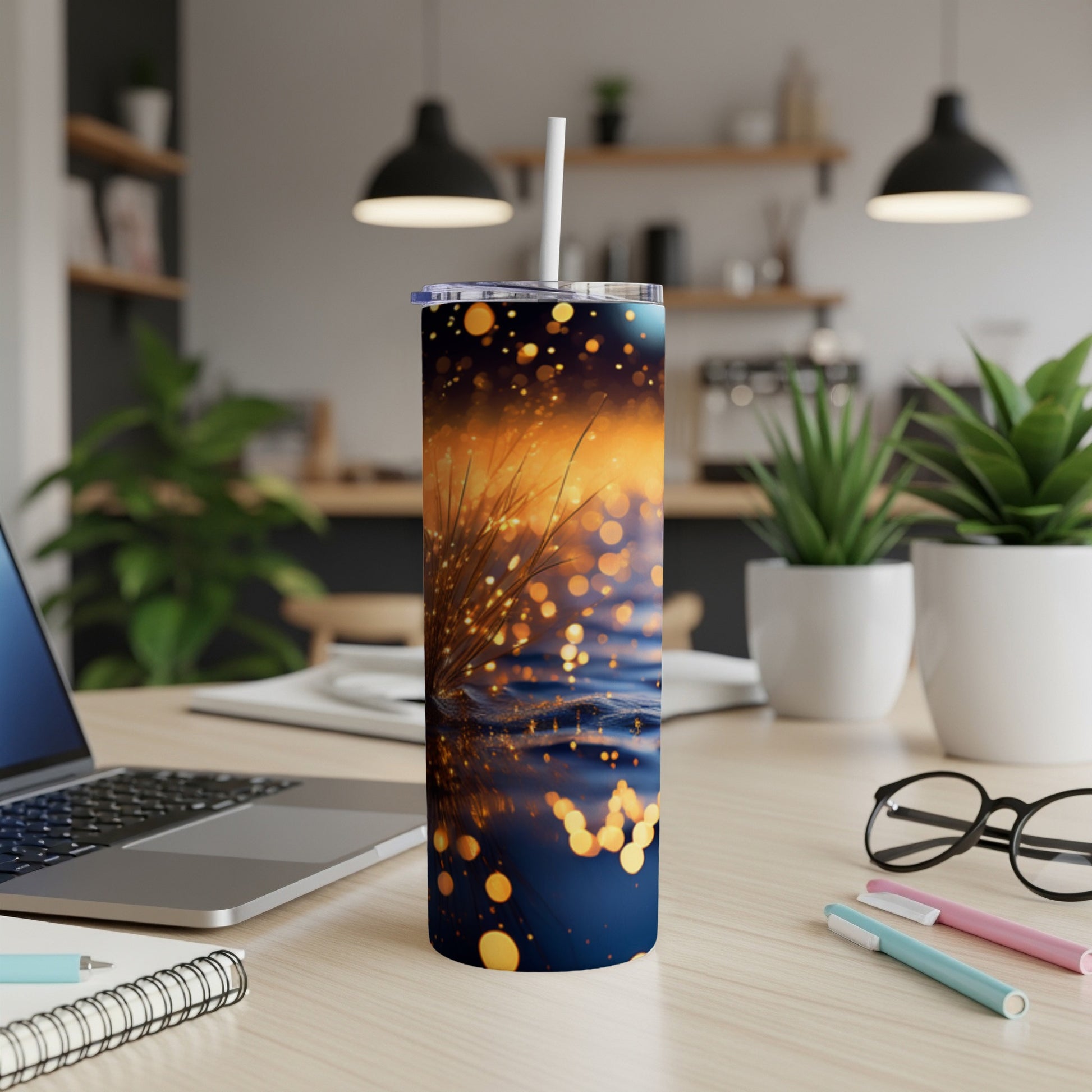 Tall tumbler with sparkling gold and blue bokeh design and white straw.