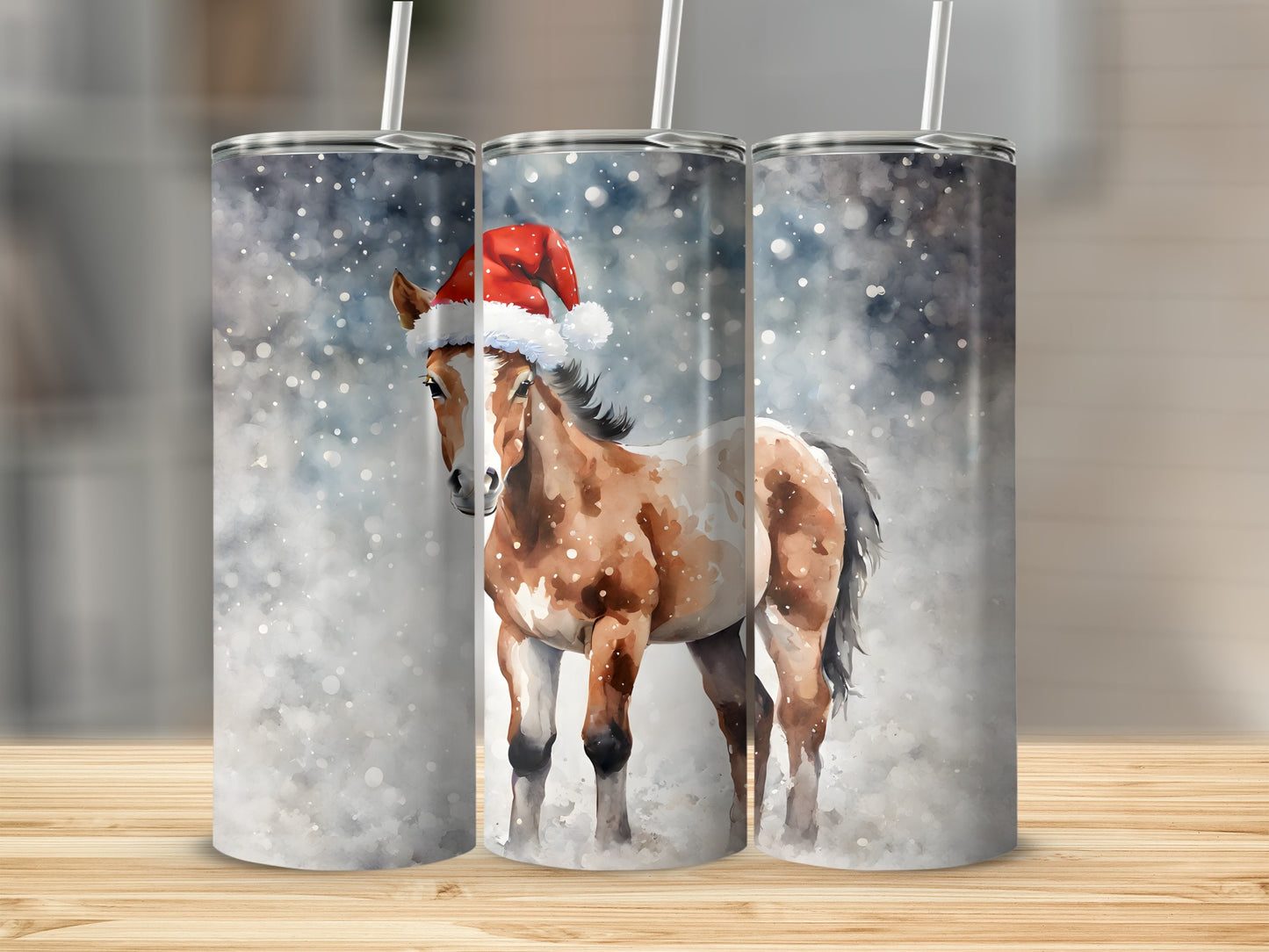 Three tumblers featuring a painted horse wearing a Santa hat in falling snow.