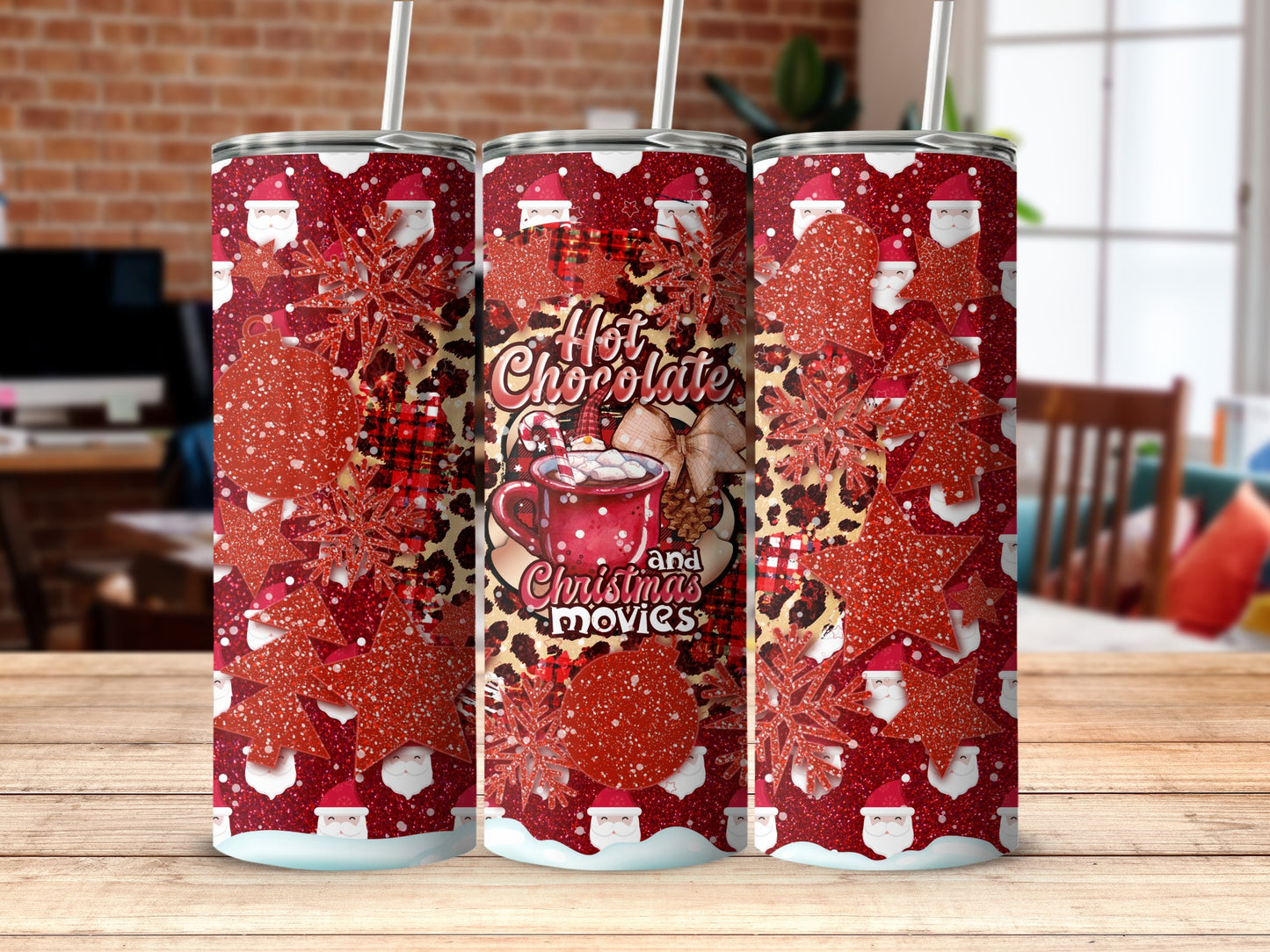 Three tumblers with a red and gold buffalo plaid, snowflake, and Santa Claus pattern.