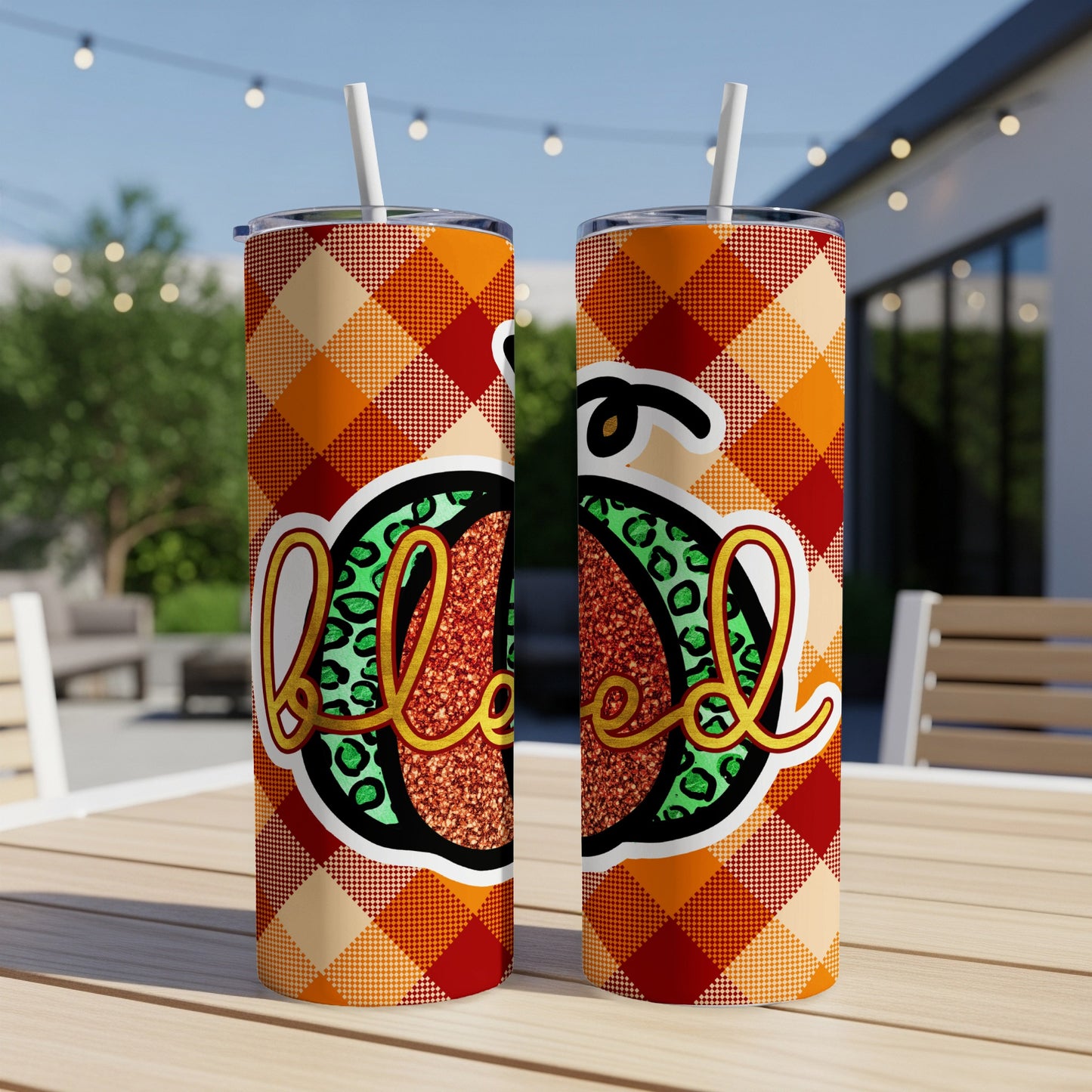 Two tall tumblers with plaid and glitter "Blessed" design on outdoor table.