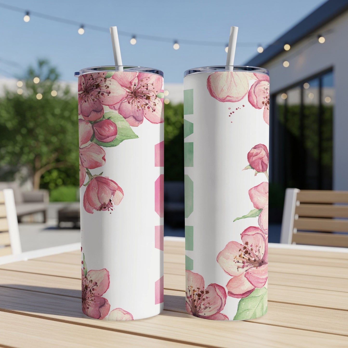Two tumblers with pink floral design and "MOM" text on a table.